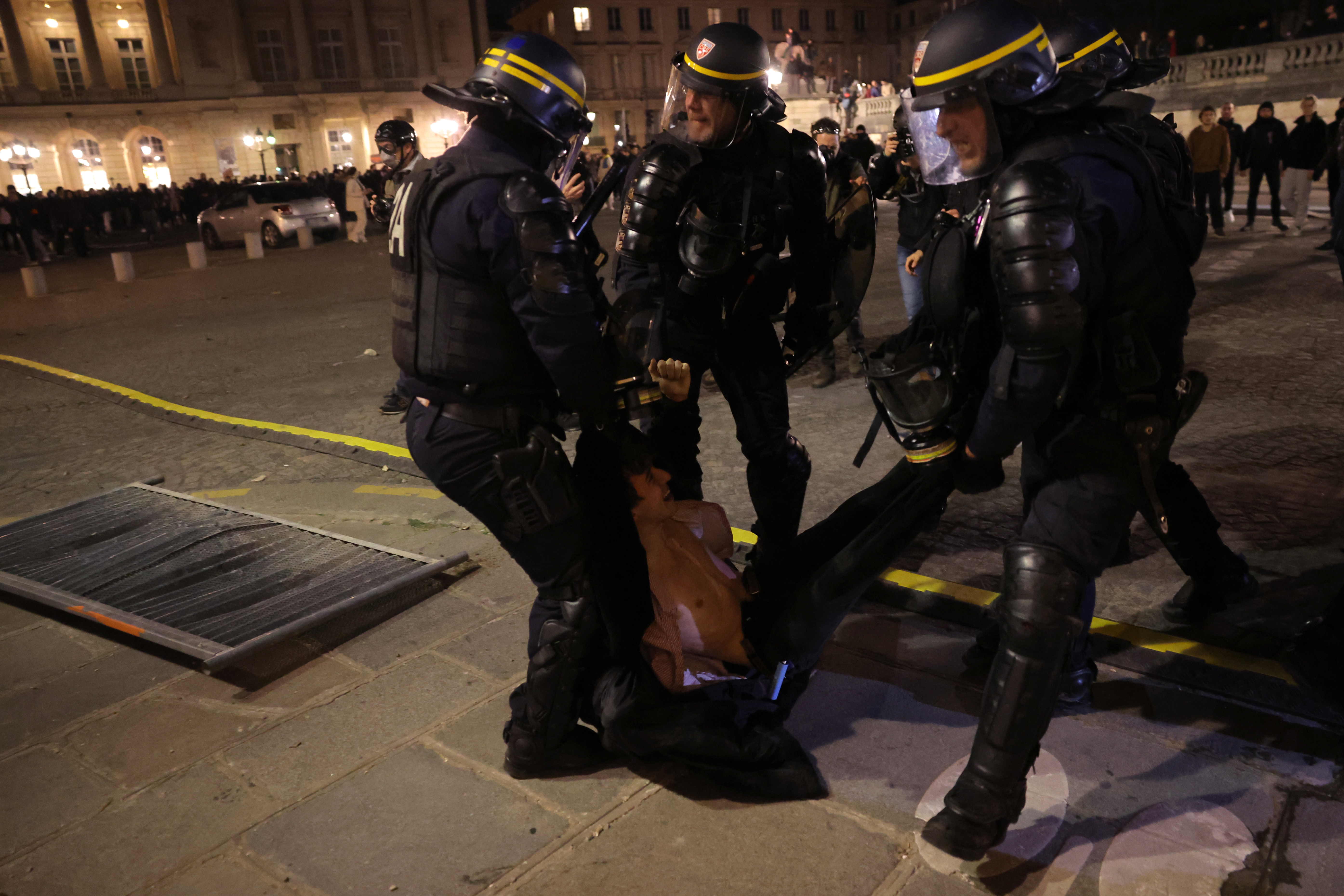 French police of the Republican Security Corps (CRS - Compagnies Republicaines de Securite) detain a protestor during a demonstration on Place de la Concorde after the French government pushed a pensions reform through parliament without a vote, using the article 49,3 of the constitution, in Paris on March 16, 2023. - The French president on March 16 rammed a controversial pension reform through parliament without a vote, deploying a rarely used constitutional power that risks inflaming protests. The move was an admission that his government lacked a majority in the National Assembly to pass the legislation to raise the retirement age from 62 to 64. (Photo by Thomas SAMSON / AFP)