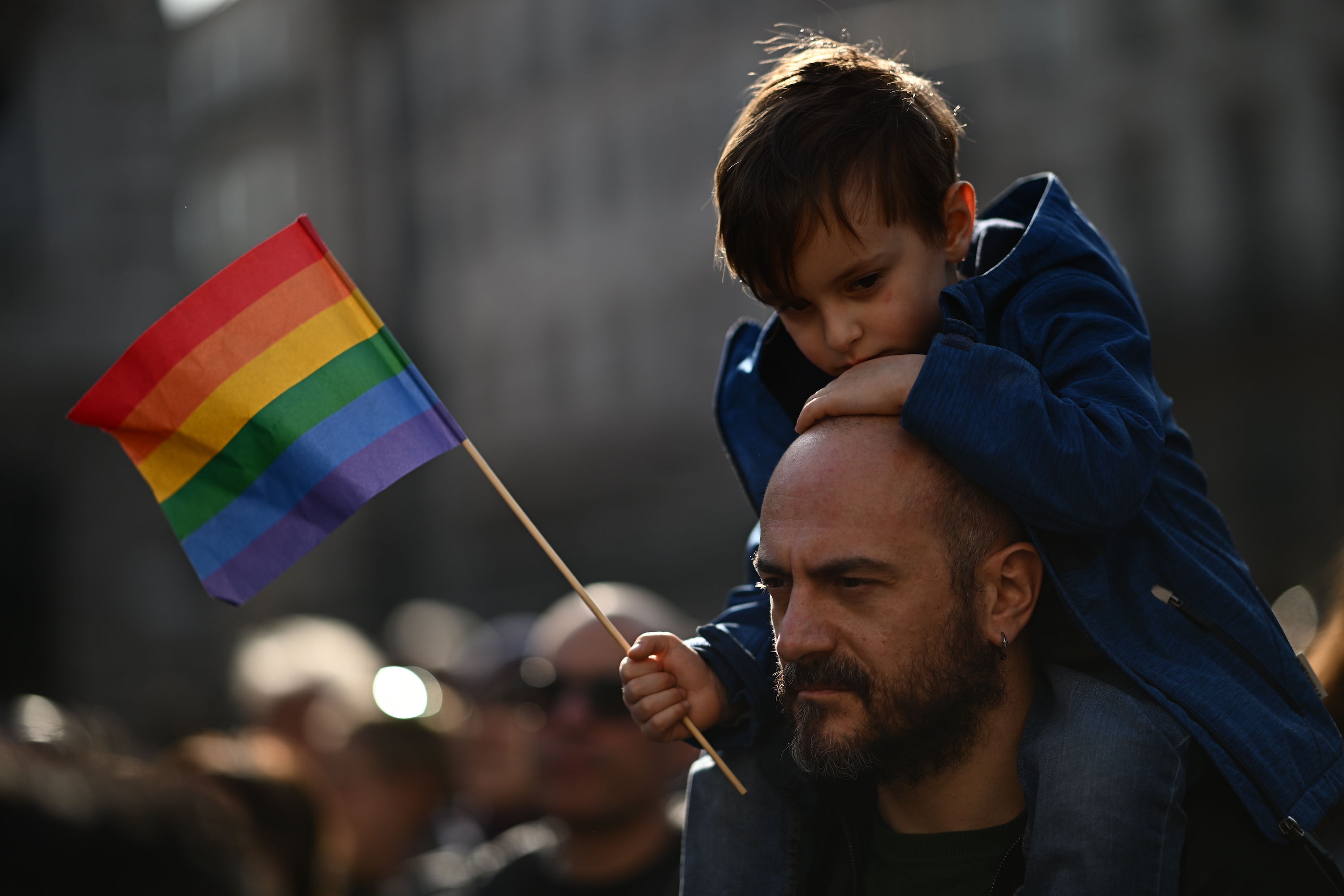 A man carries a boy on his shoulders during a demonstration by gay rights and civil society groups in Milan