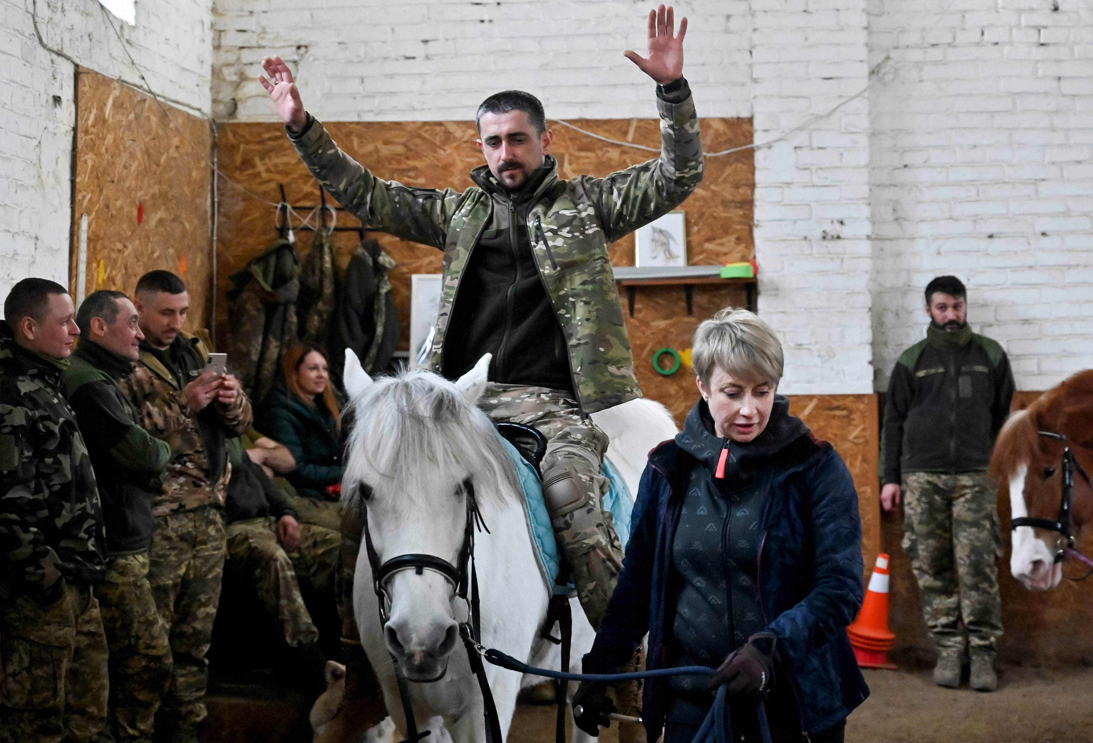 A Ukrainian serviceman rides a horse during a hippotherapy session in Kyiv