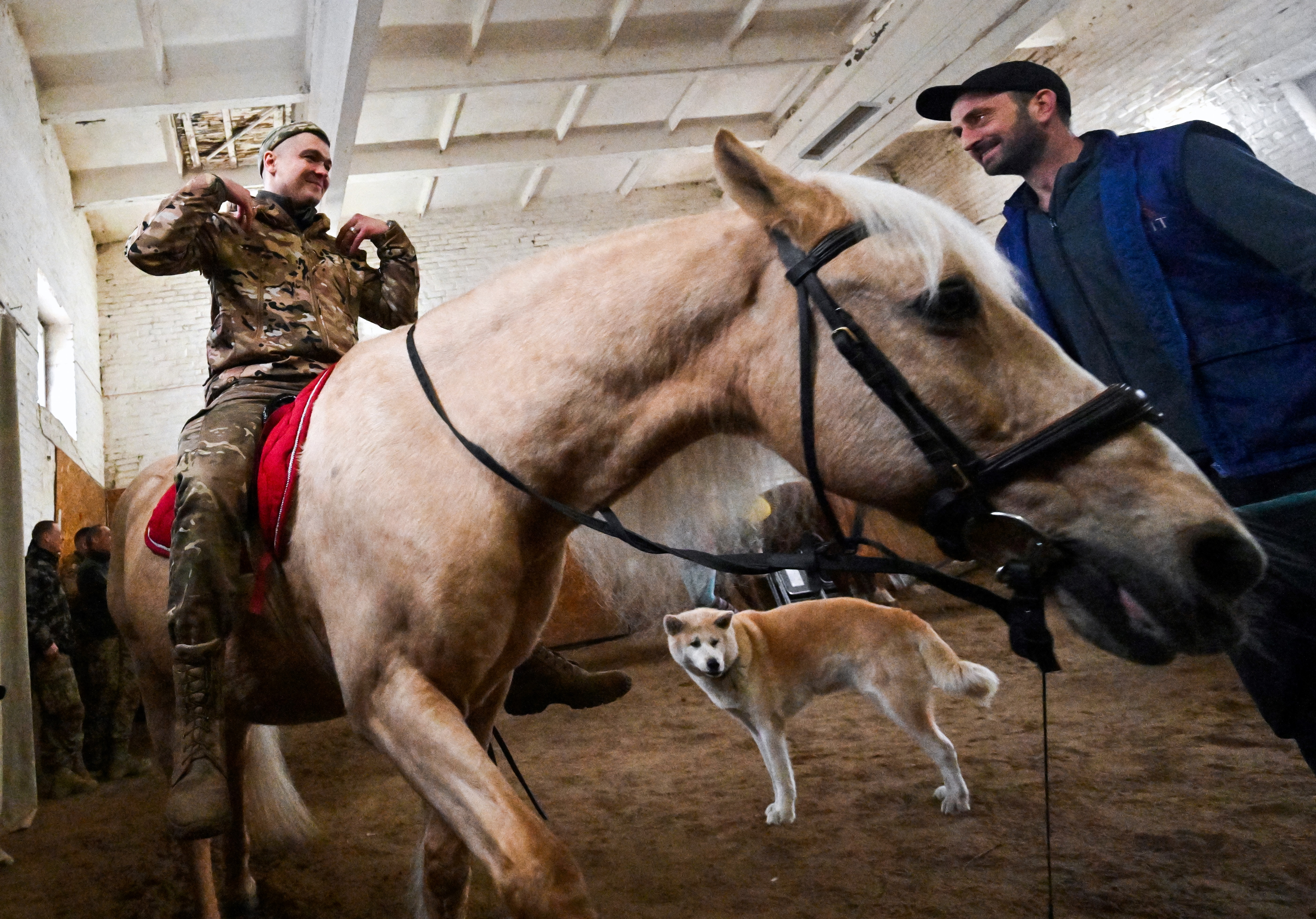 A Ukrainian serviceman rides a horse during a hippotherapy session in Kyiv