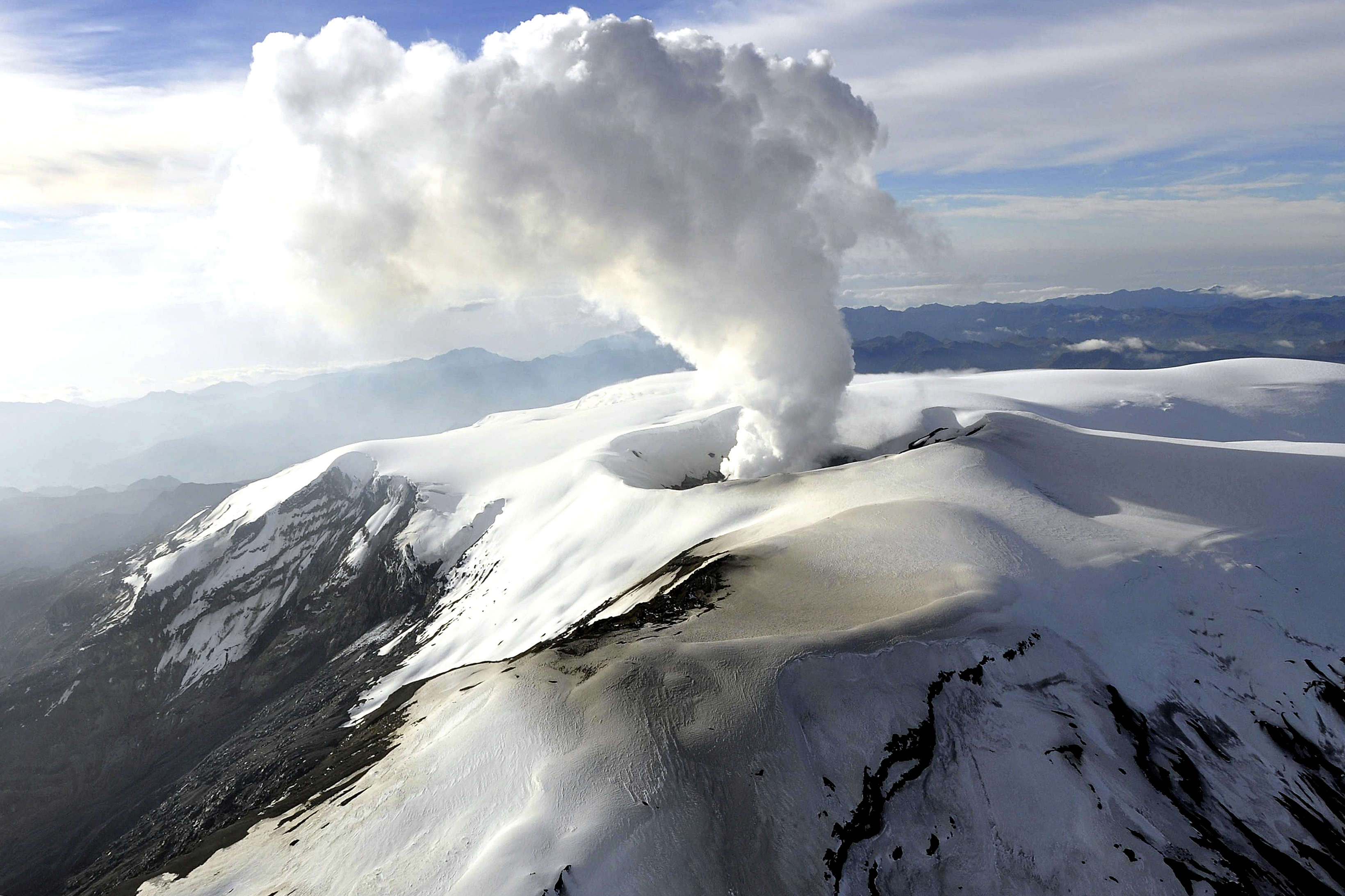 A snowy volcanic peak with smoke pouring out