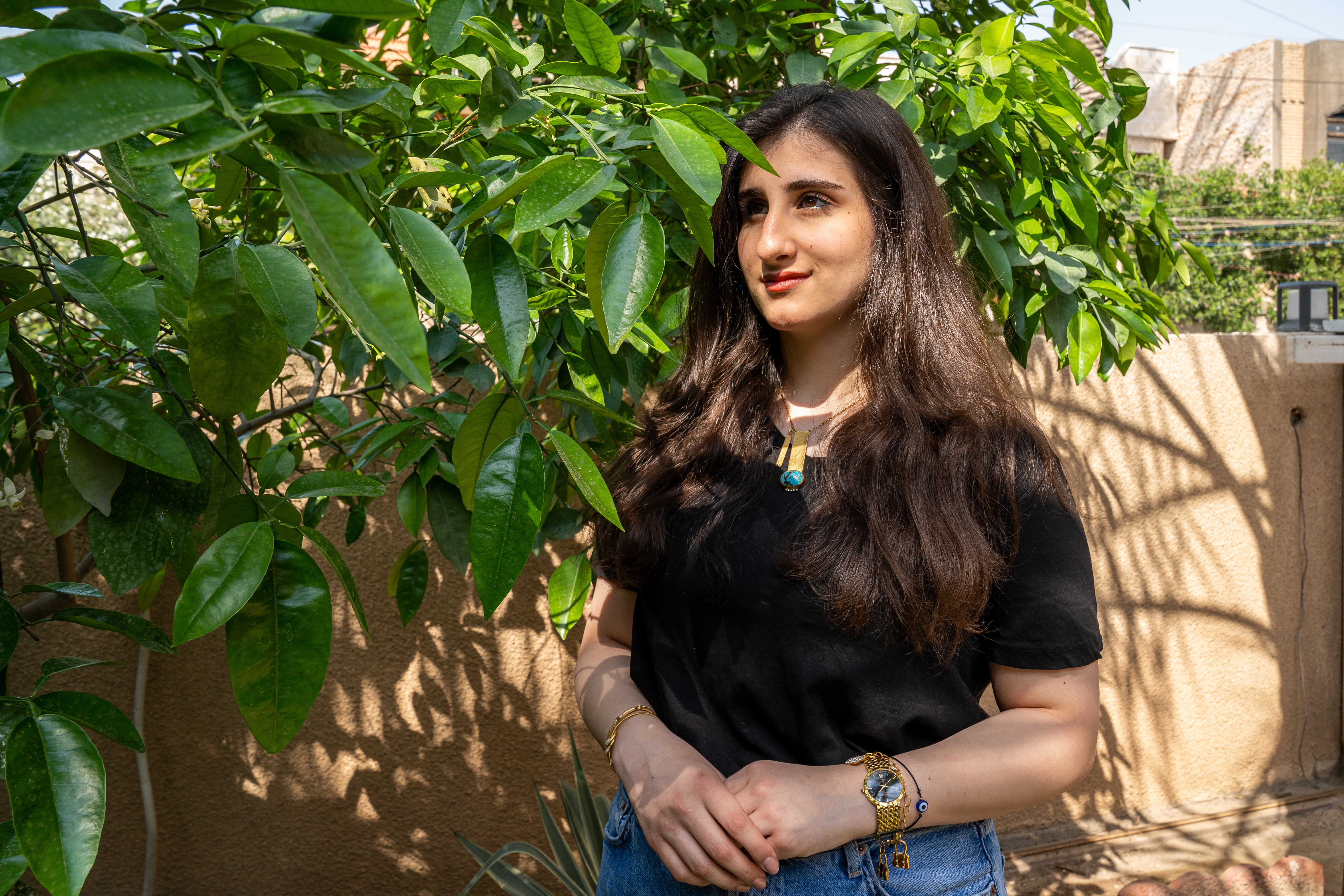 A photo of Mayar standing next to a tree.