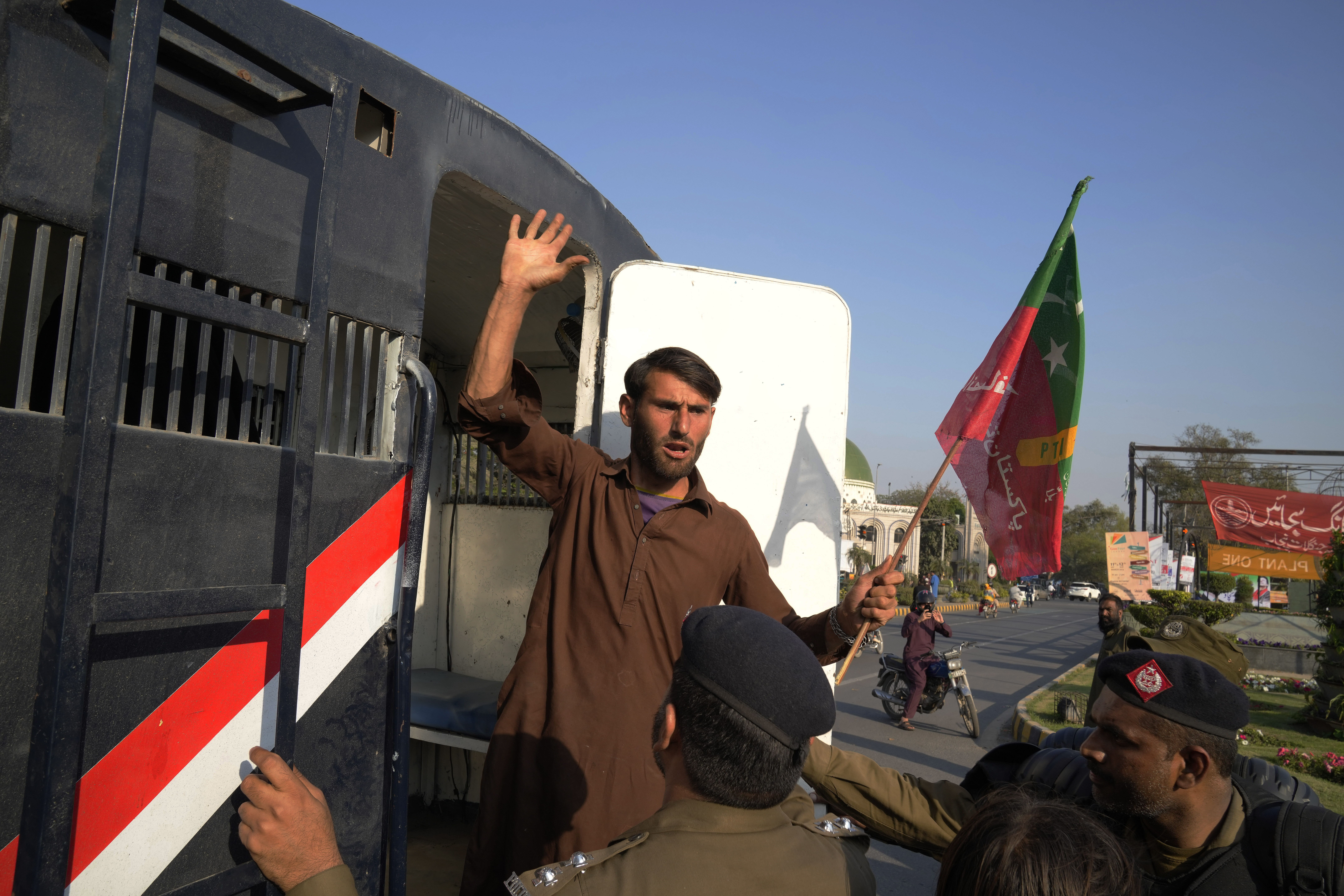 Police officers detain a supporter of Pakistan's former Prime Minister Imran Khan in Lahore.