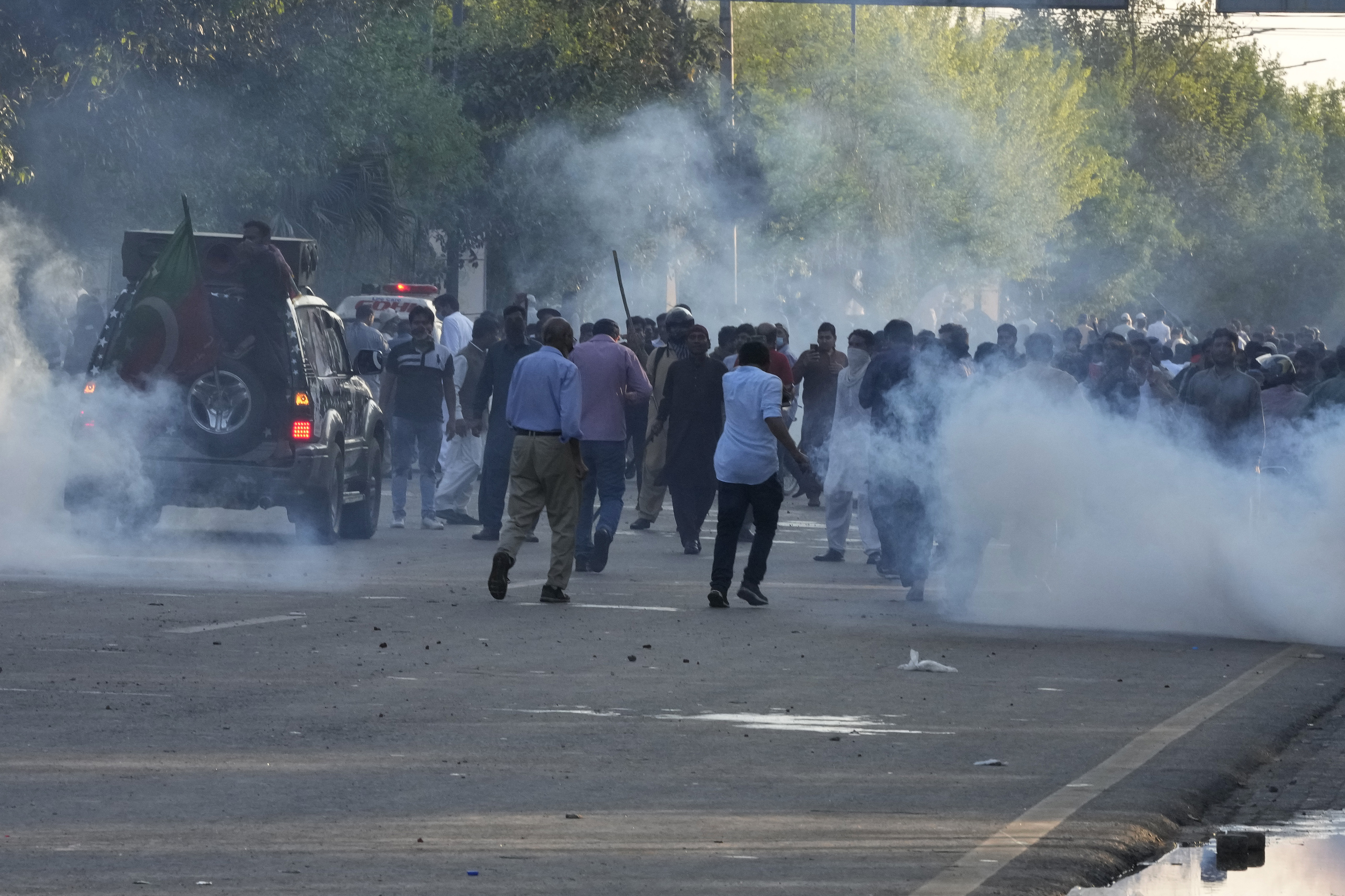 Supporters of Pakistan's former Prime Minister Imran Khan run for cover as police fire tear gas shells.