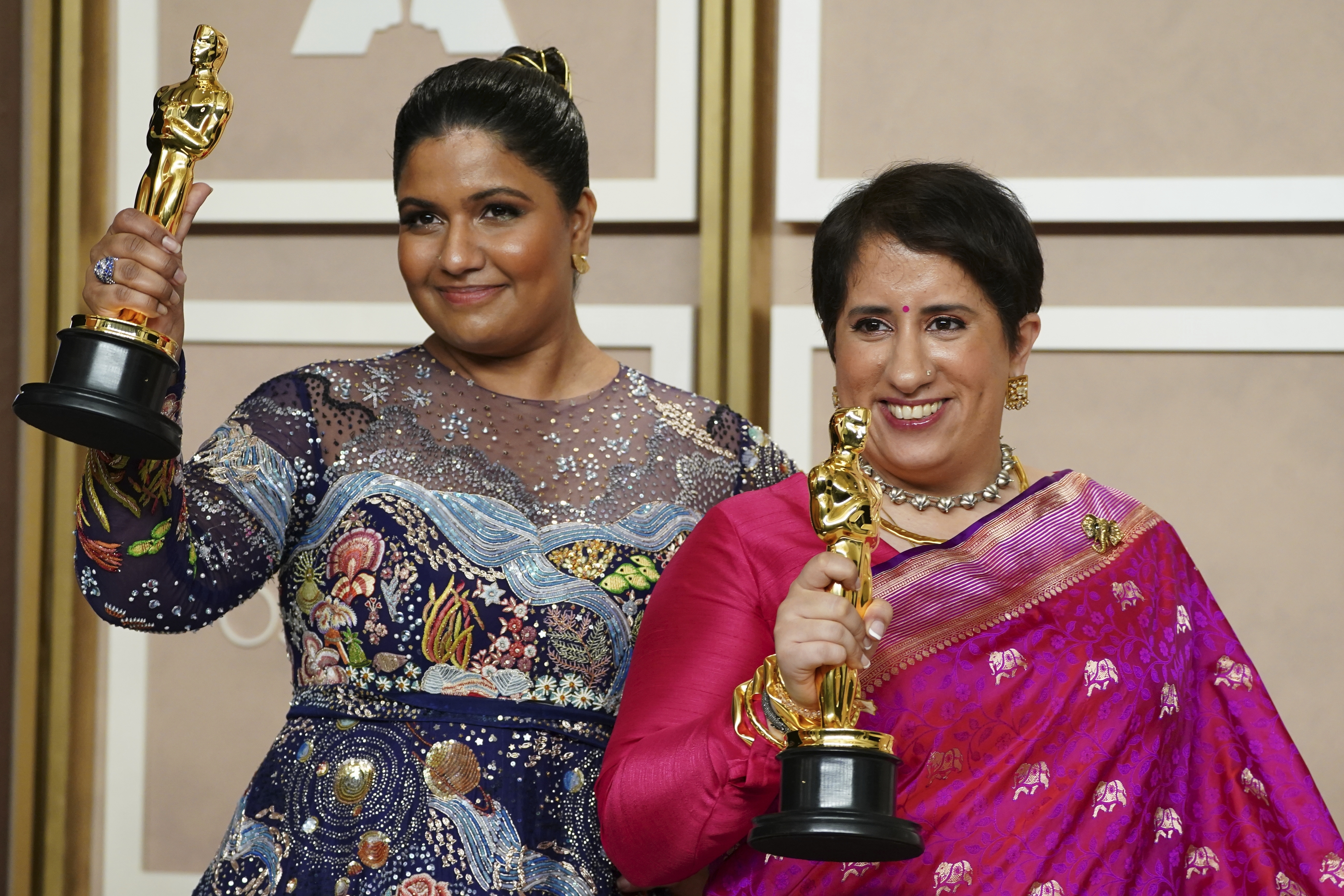 Kartiki Gonsalves, left, and Guneet Monga hold their Oscars