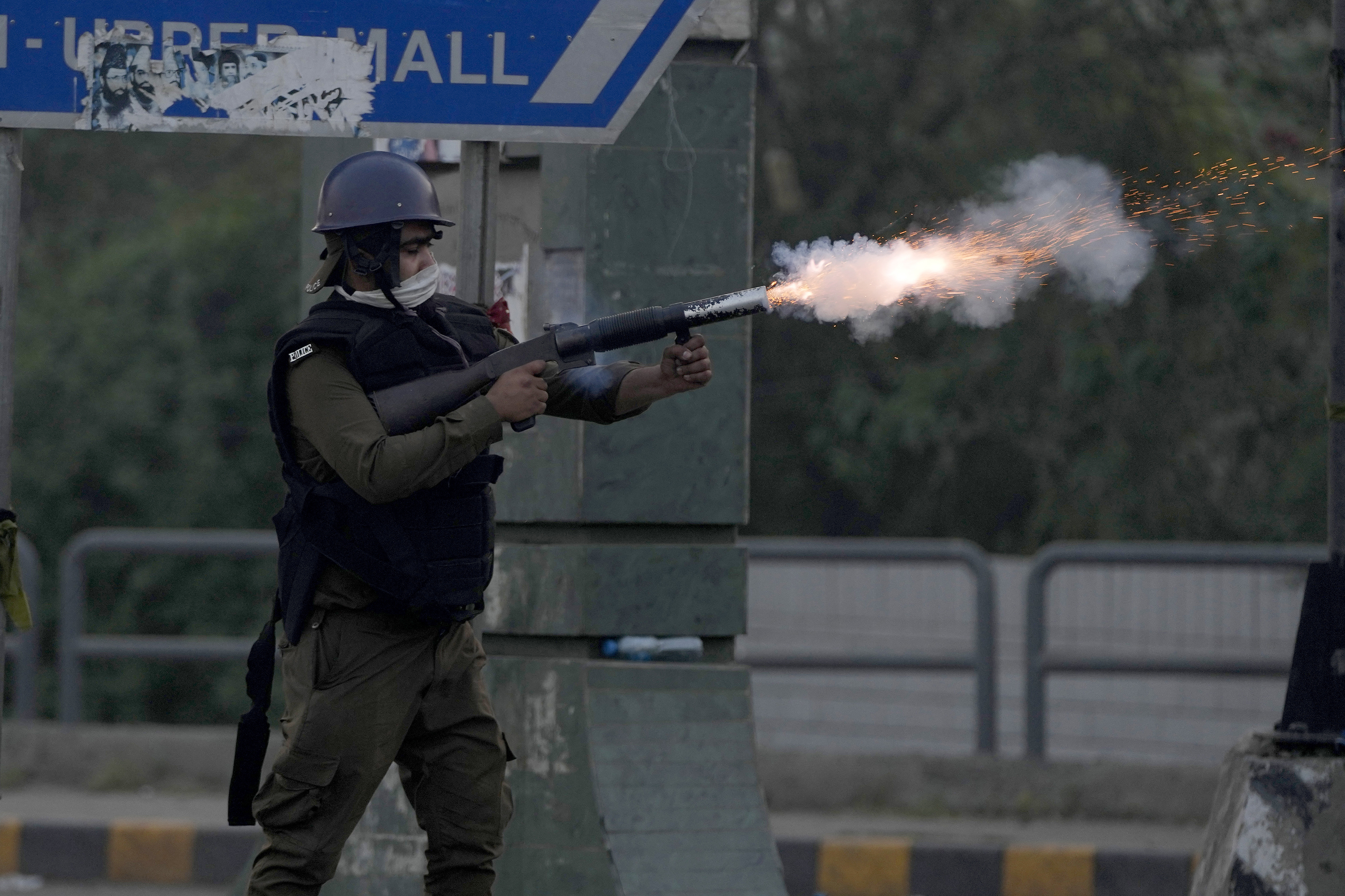 A riot police officer fires tear gas to disperse supporters of former Prime Minister Imran Khan