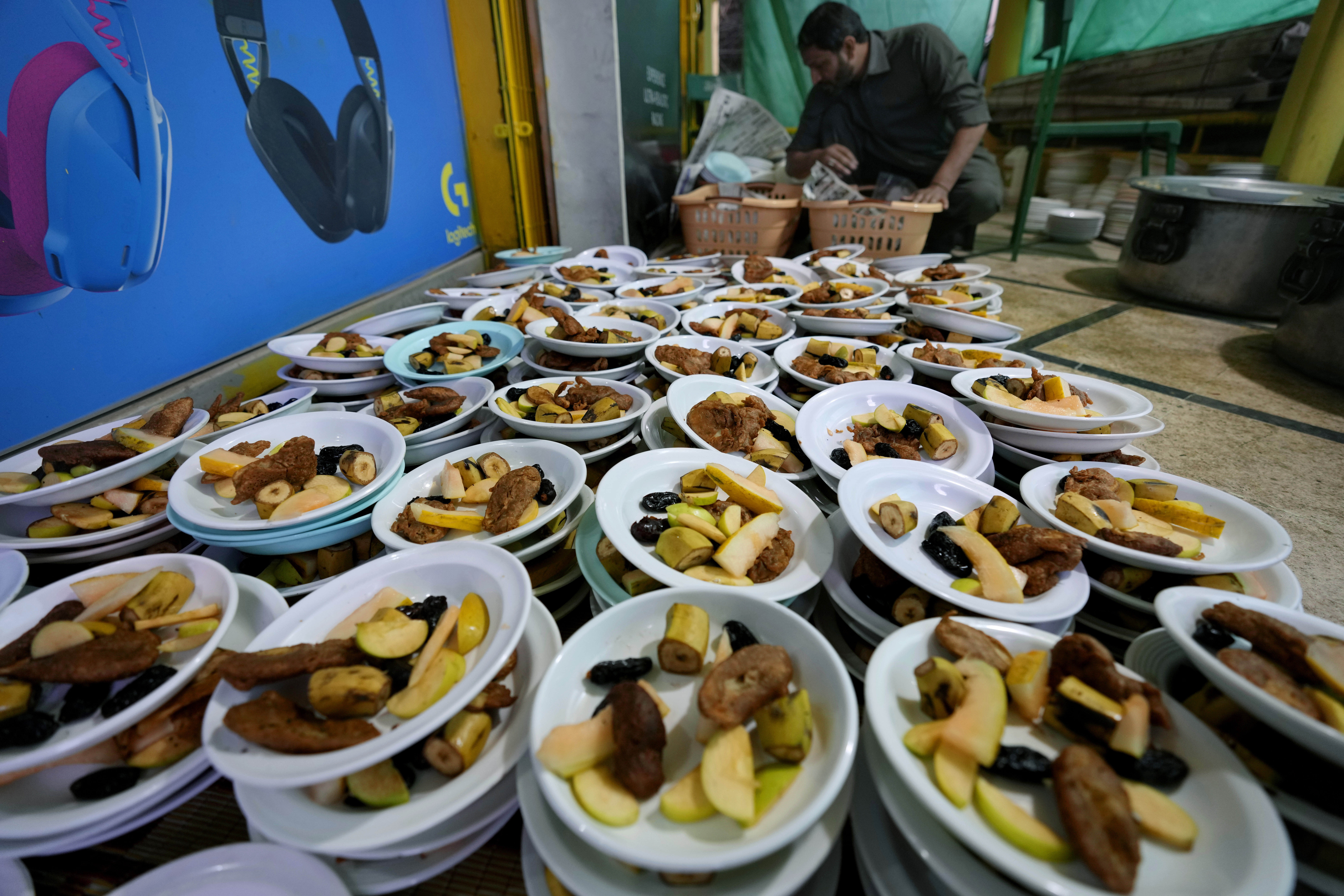 A volunteer prepares food plate to be distributed among people for breaking their fast during the Muslims holy fasting month of Ramadan, in a mosque, in Rawalpindi, Pakistan.