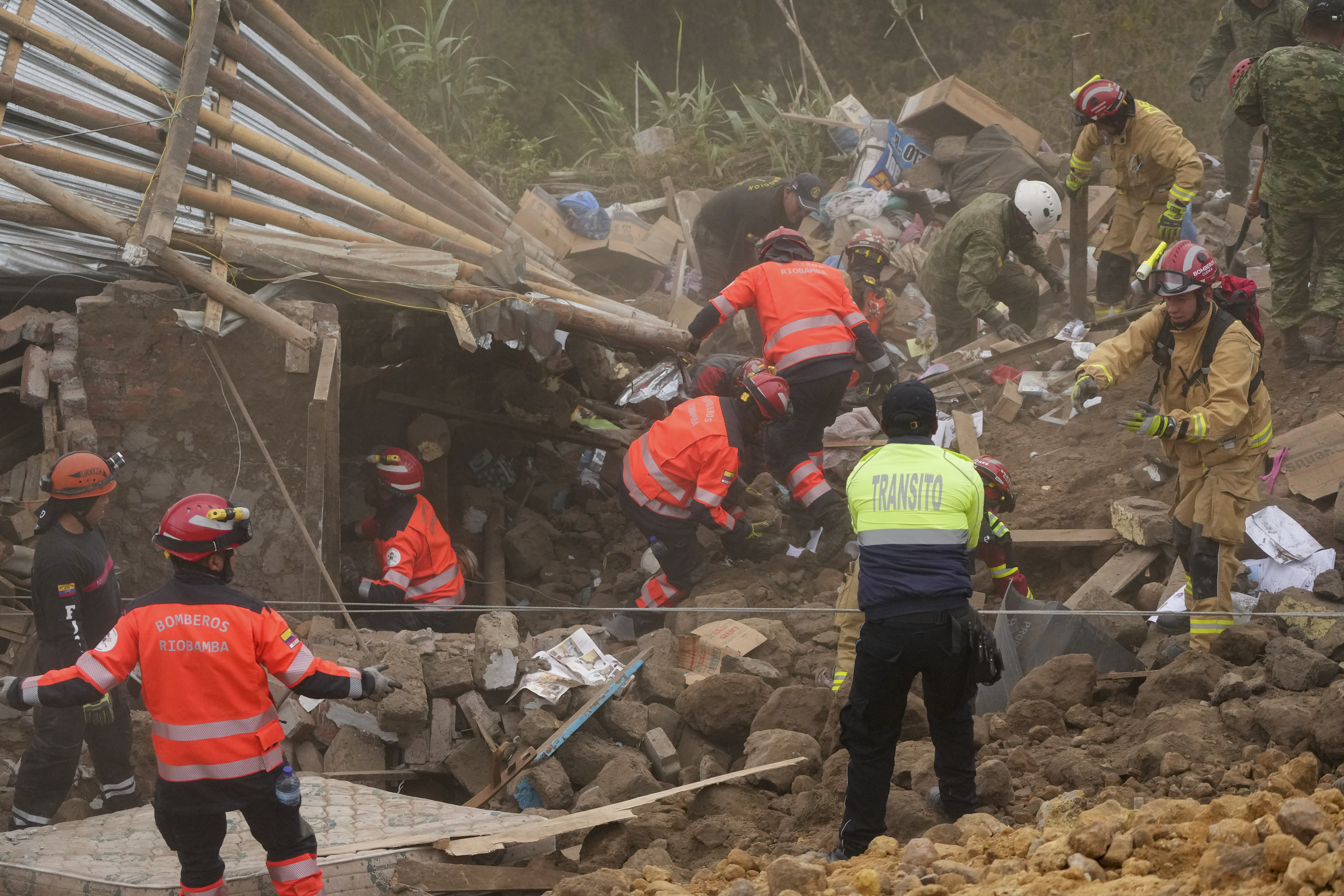 Rescue workers inspect a home destroyed by a deadly landslide that buried dozens of homes in Alausi, Ecuador