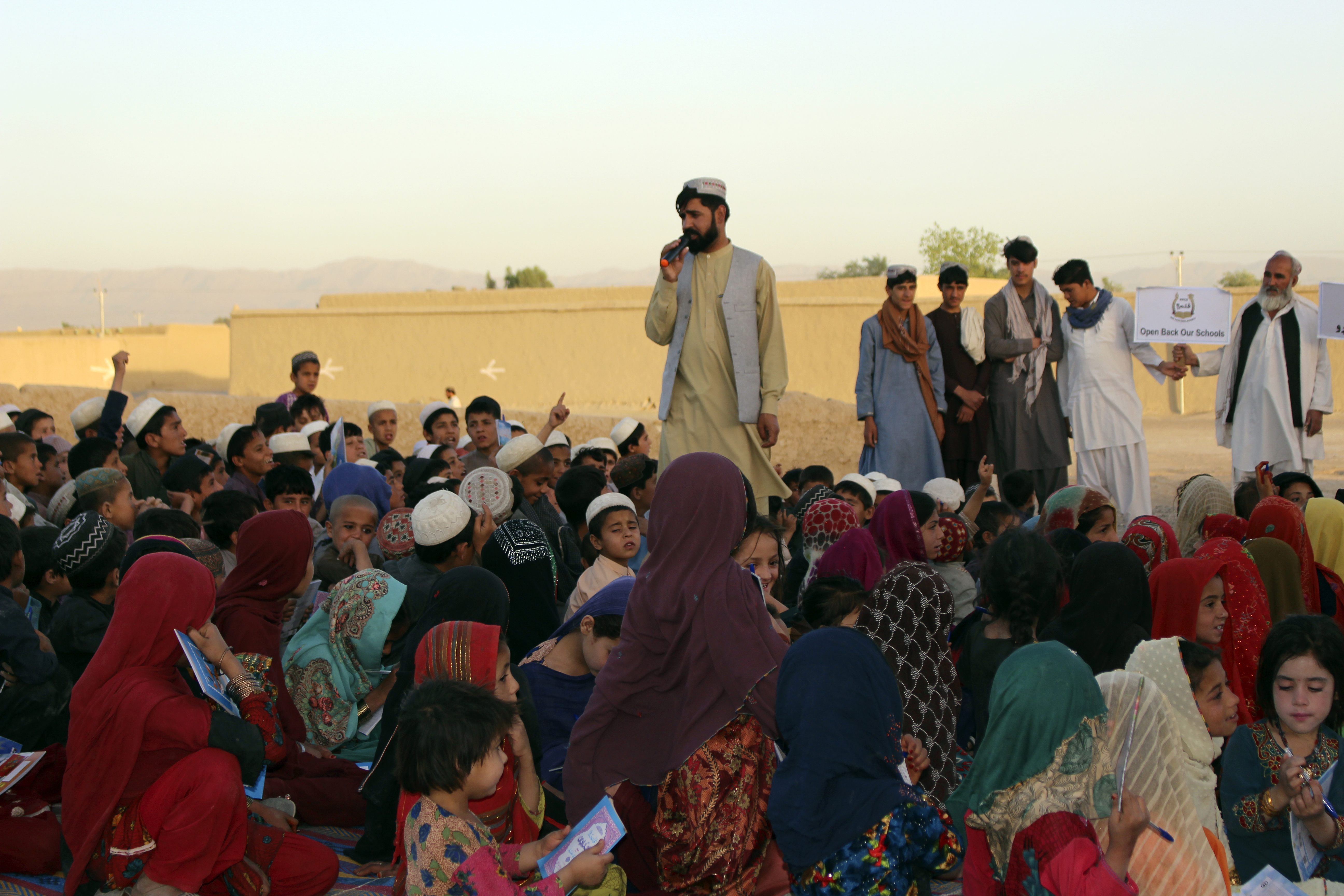 Matiullah Wesa, a girls' education advocate, reads to students in the open area in Spin Boldak district in the southern Kandahar province.