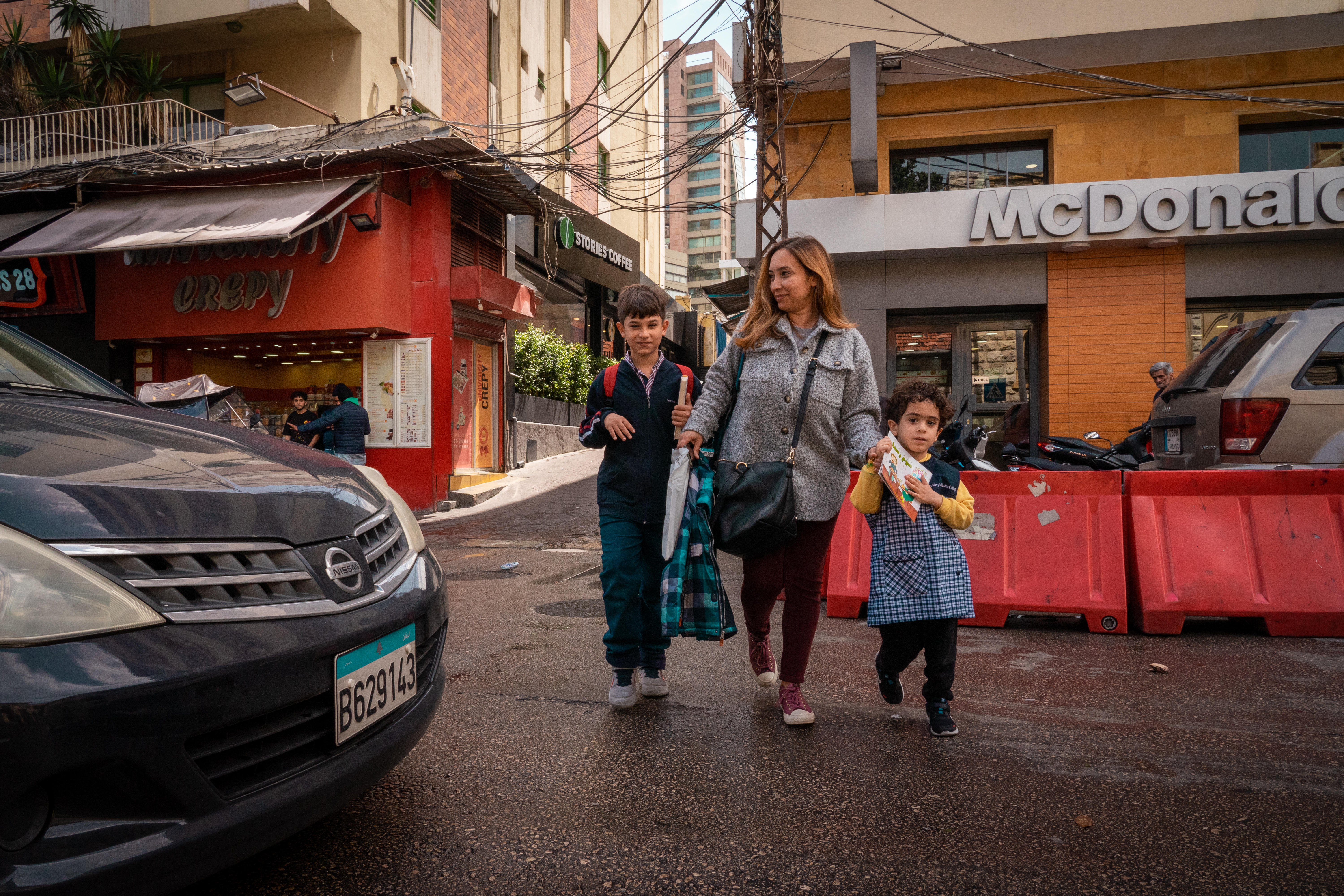 Dania and her two children cross the road
