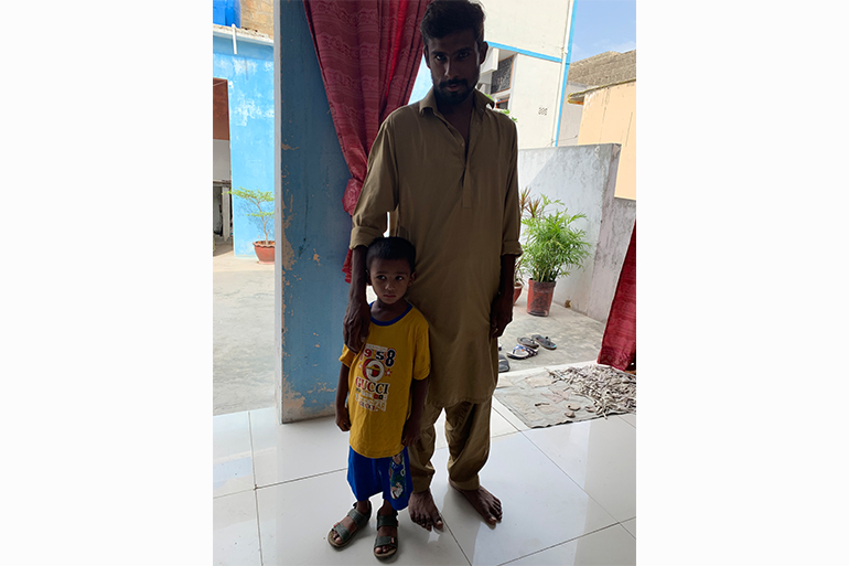 A photo of a man standing with his child.