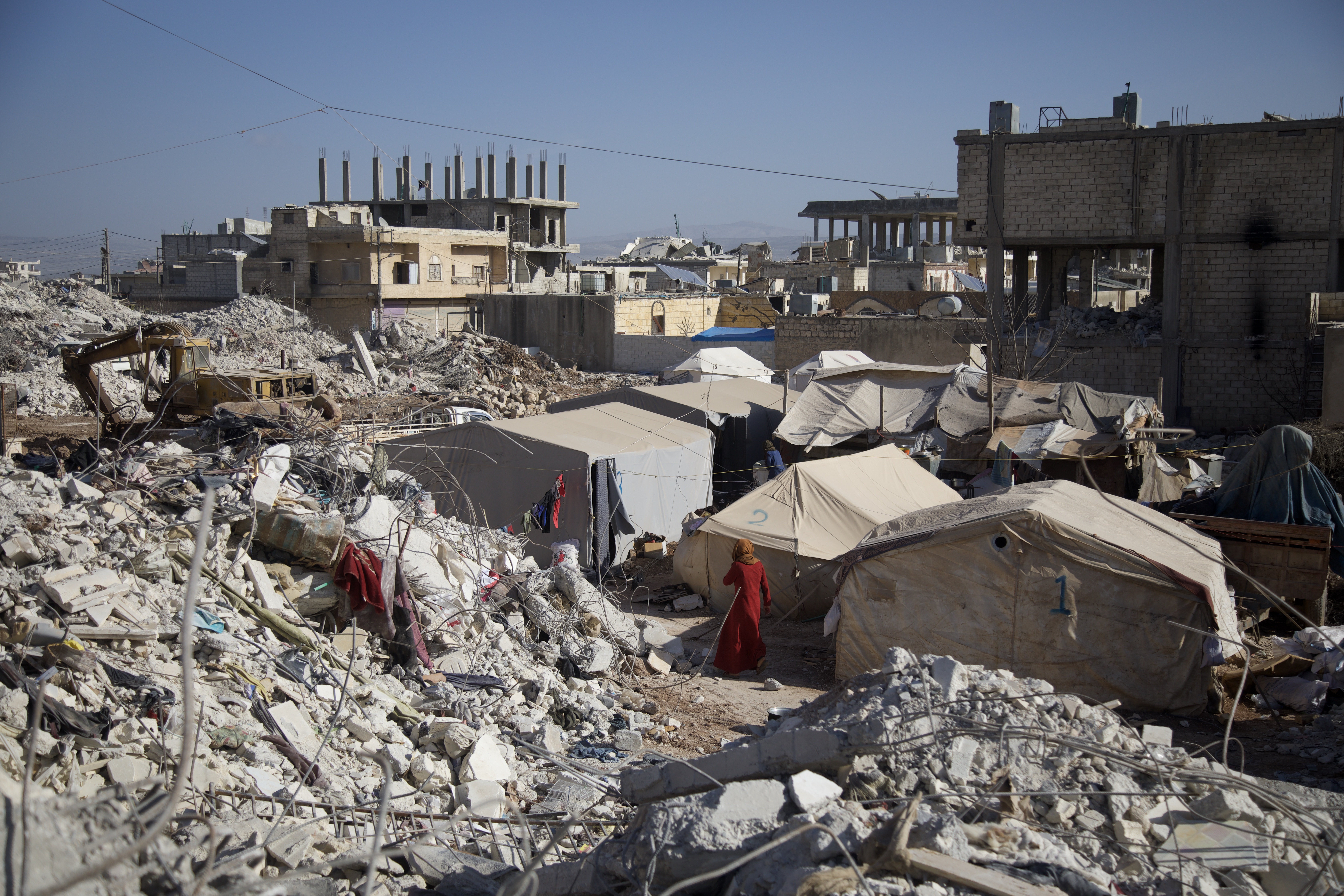 View of tents pitched haphazardly in the midst of mountains of rubble