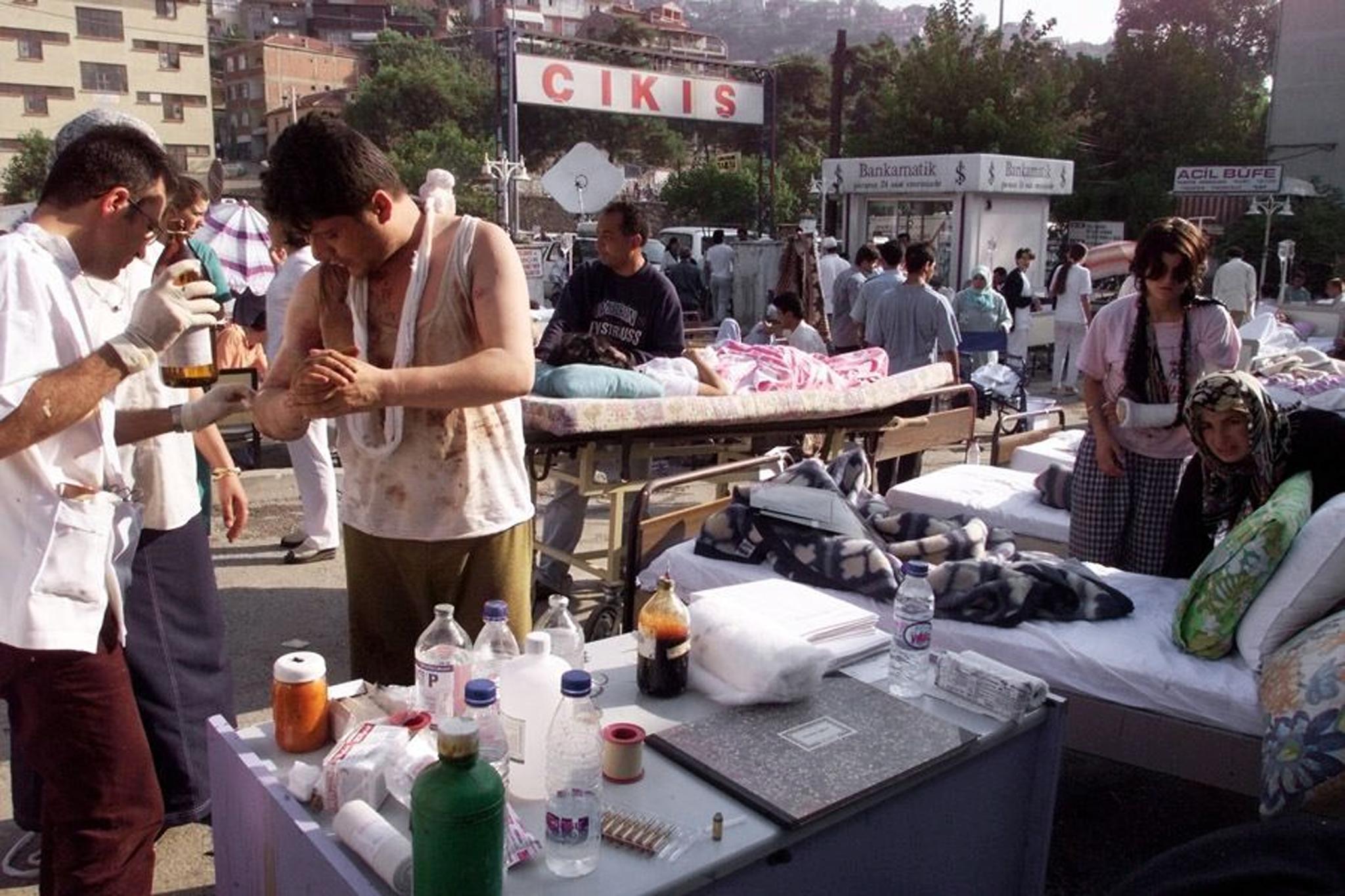 Injured people are treated 18 August 1999 in the courtyard of a hospital in Izmit, 150 kms east of Istanbul on the Marmara Sea, where the death toll rose to at least 2,000 following the 17 August 1999 earthquake, measuring 7.4 on the open-ended Richter scale. The Turkish government crisis center counted 18 August 1999 3,839 dead and more than 19,000 injured in the central and western Anatolian provinces. (ELECTRONIC IMAGE) (Photo by PIERRE VERDY / AFP)
