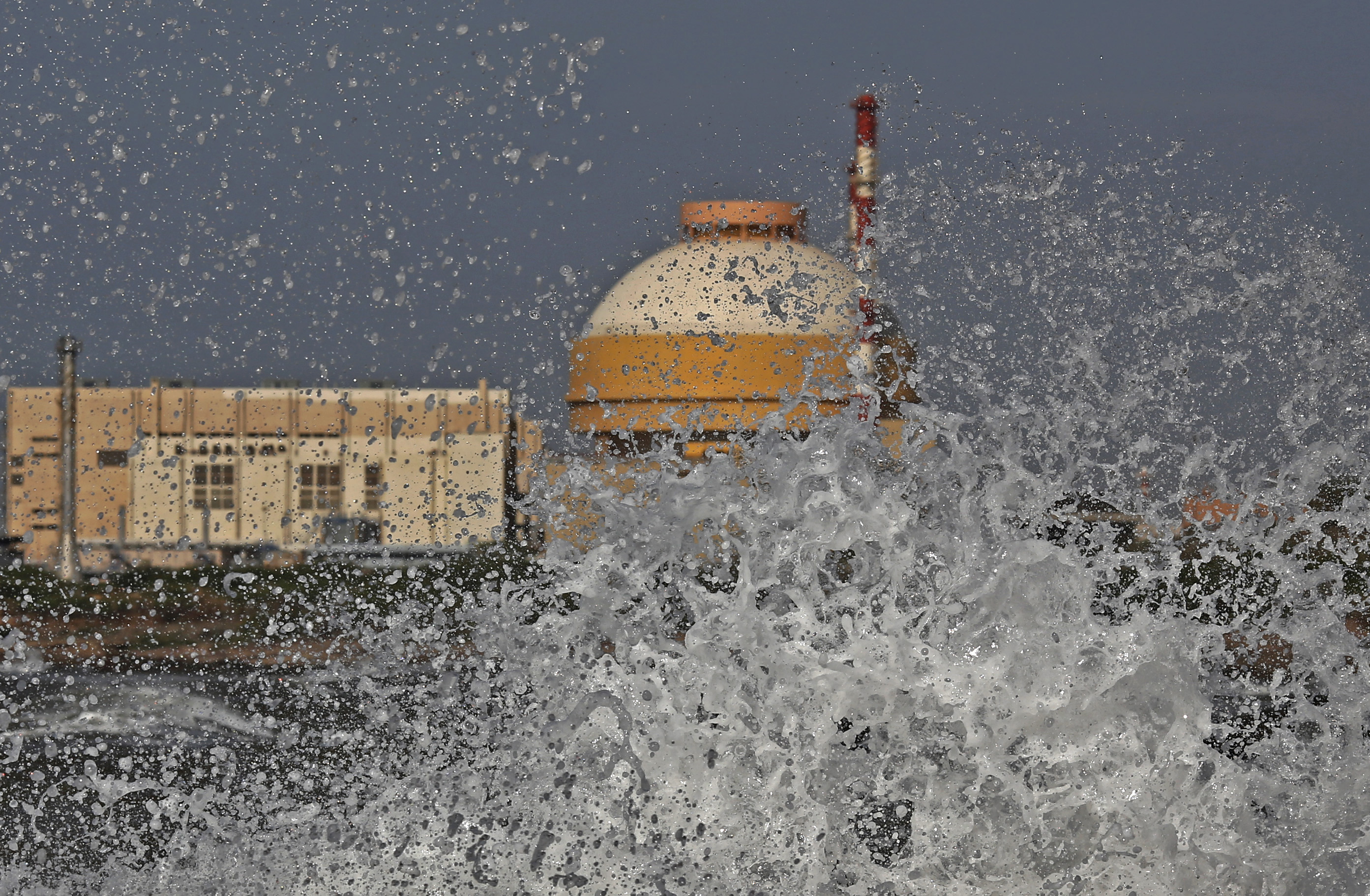 Sea waves hit the rocks as Kudankulam nuclear power project plant is seen in the background in the southern Indian state of Tamil Nadu