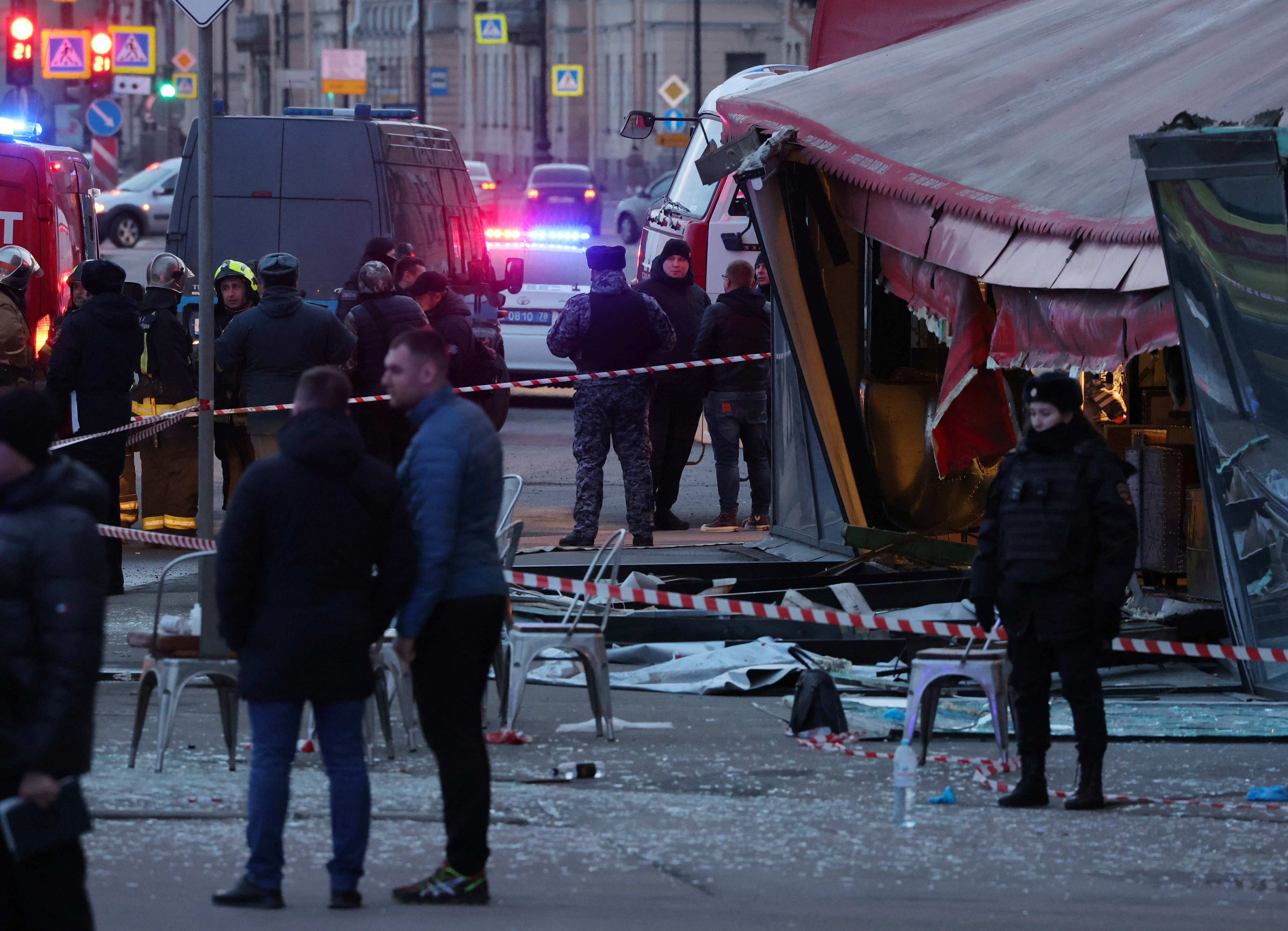 Investigators and members of emergency services work at the site of an explosion in a cafe in Saint Petersburg