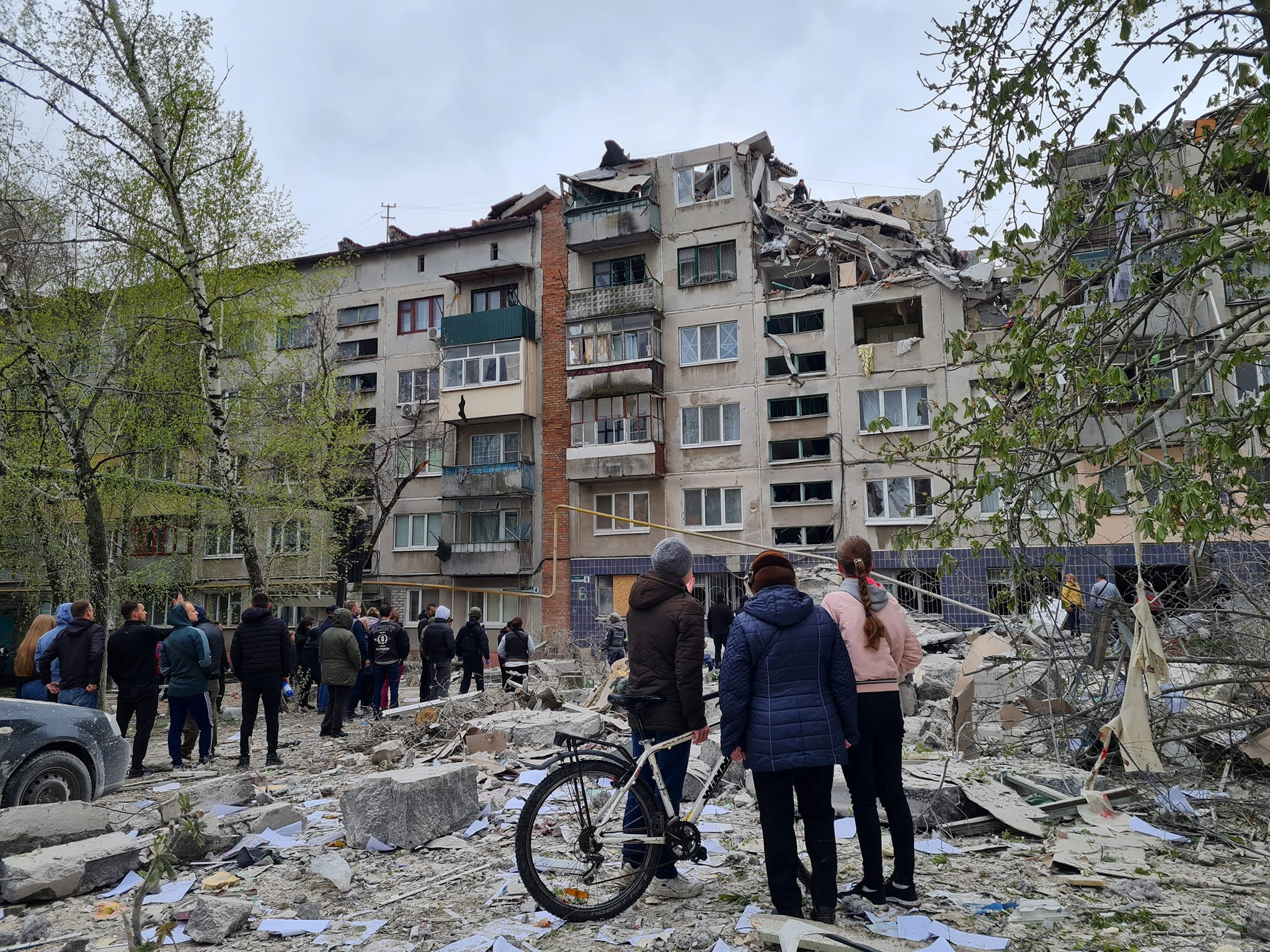 Local residents stand next to an apartment building damaged by a Russian military strike, amid Russia's attack on Ukraine, in Sloviansk, Donetsk region, Ukraine April 14, 2023. Press service of the Donetsk Regional Military-Civil Administration/Handout via REUTERS ATTENTION EDITORS - THIS IMAGE HAS BEEN SUPPLIED BY A THIRD PARTY. MANDATORY CREDIT. DO NOT OBSCURE LOGO. NO RESALES. NO ARCHIVE.