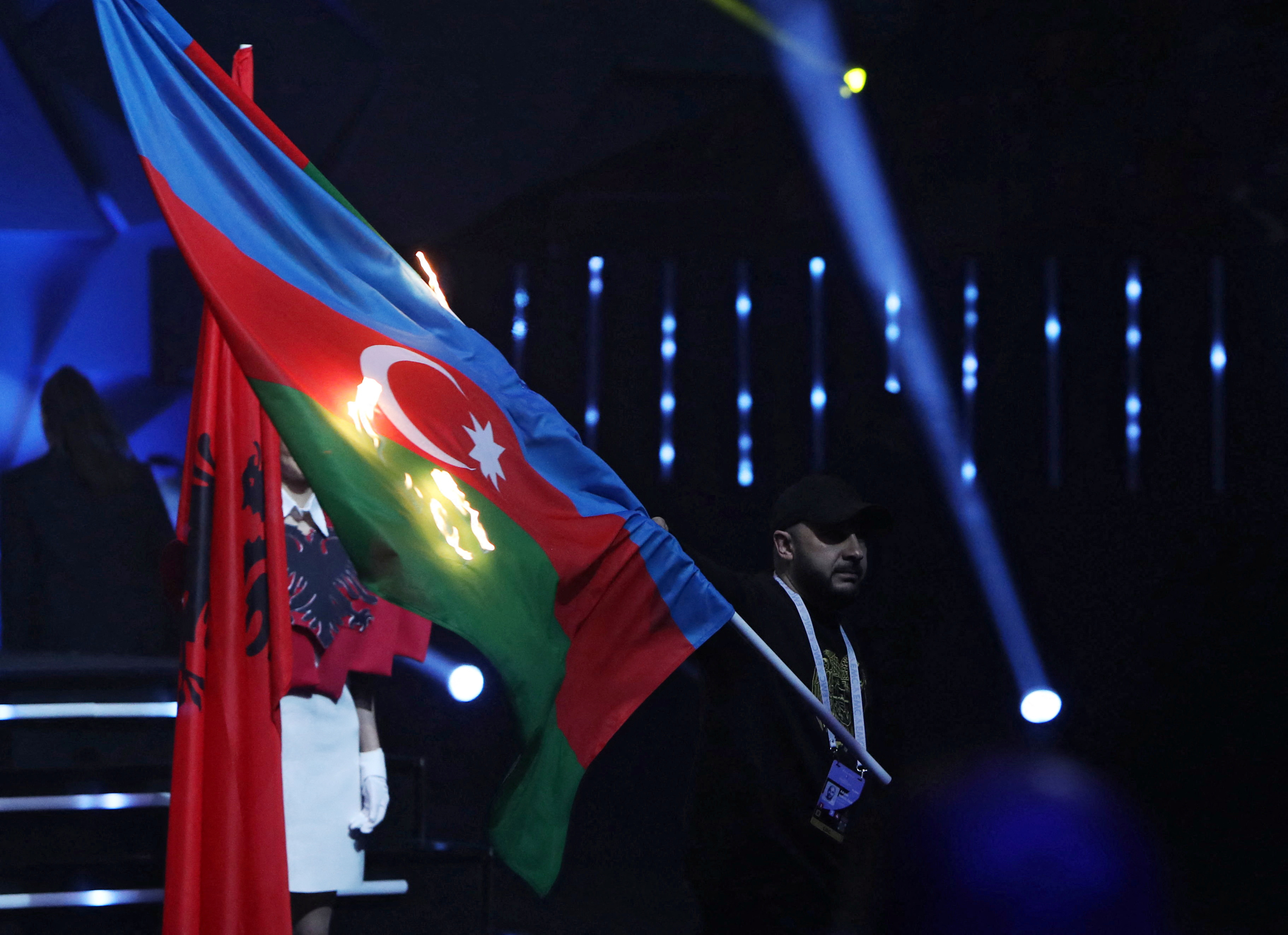 A man sets fire to the flag of Azerbaijan during the opening ceremony of the European Weightlifting Championships in Yerevan, Armenia