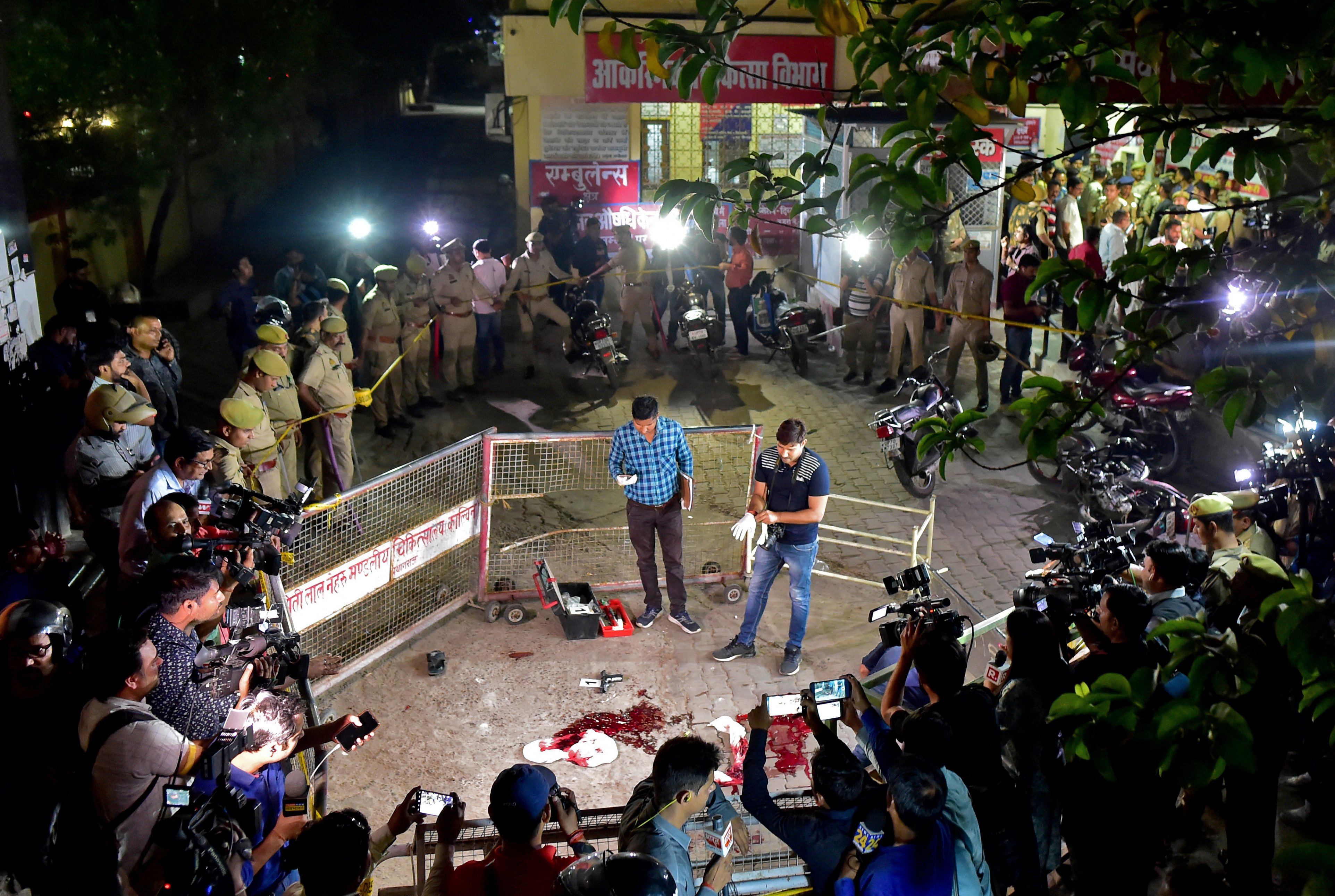Forensic officials examine the spot where Atiq Ahmed and his brother Ashraf Ahmed were shot dead