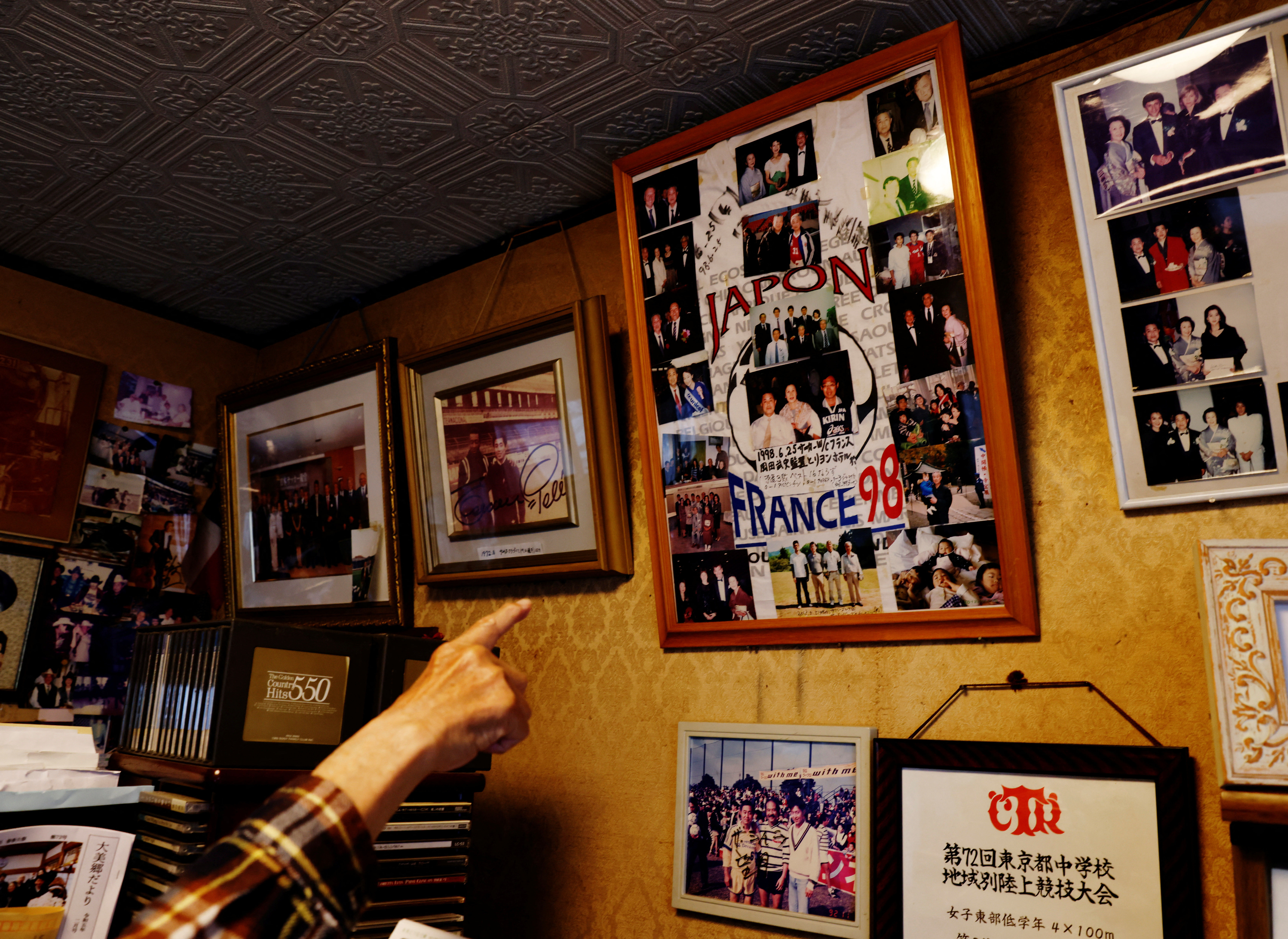 Mutsuhiko Nomura, 83, explains photos taken when he and his wife Junko Nomura, 80, traveled to France to watch the 1998 France World Cup Games