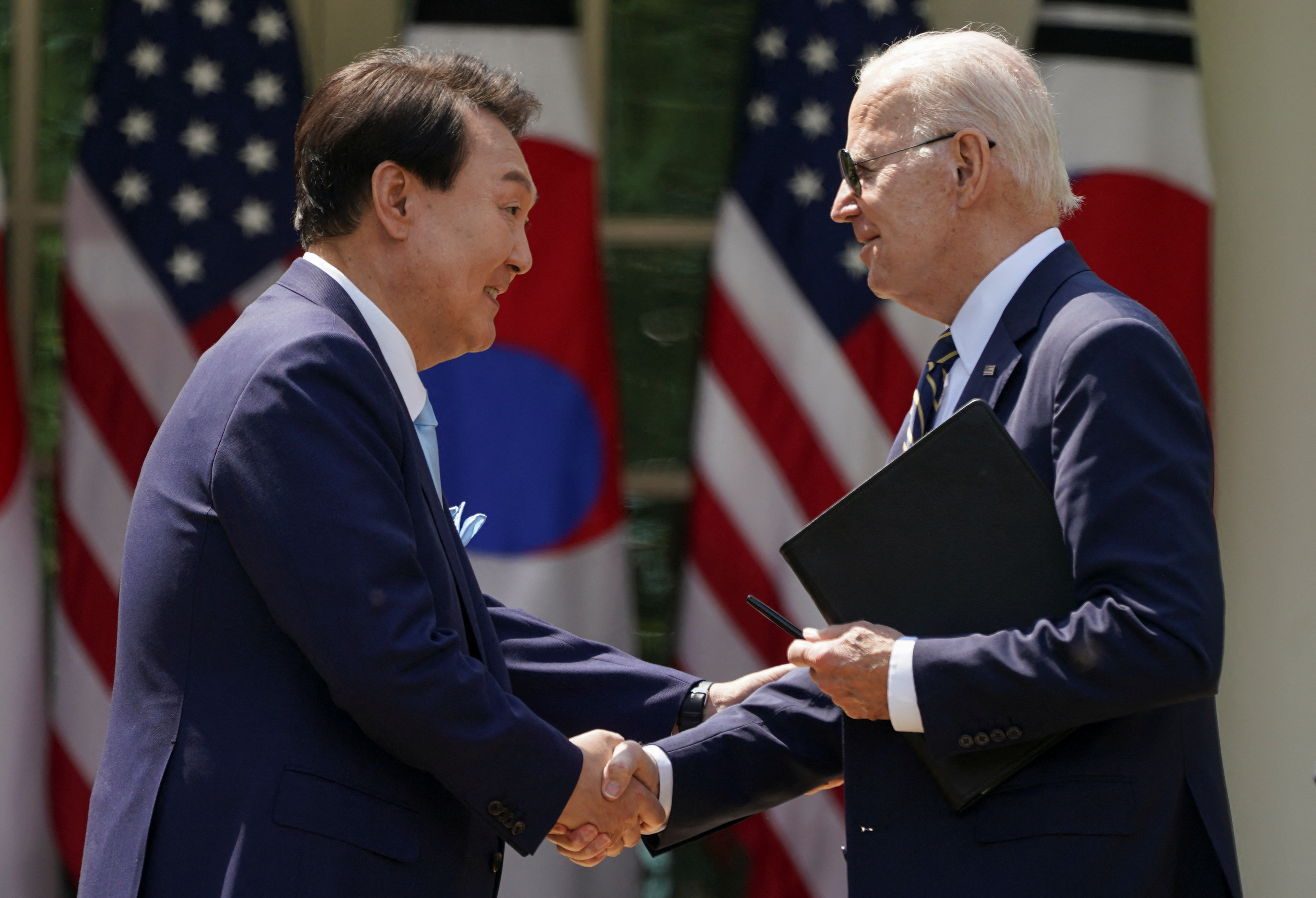 US President Joe Biden and South Korea's President Yoon Suk Yeol shake hands at the conclusion of a joint news conference in the Rose Garden of the White House