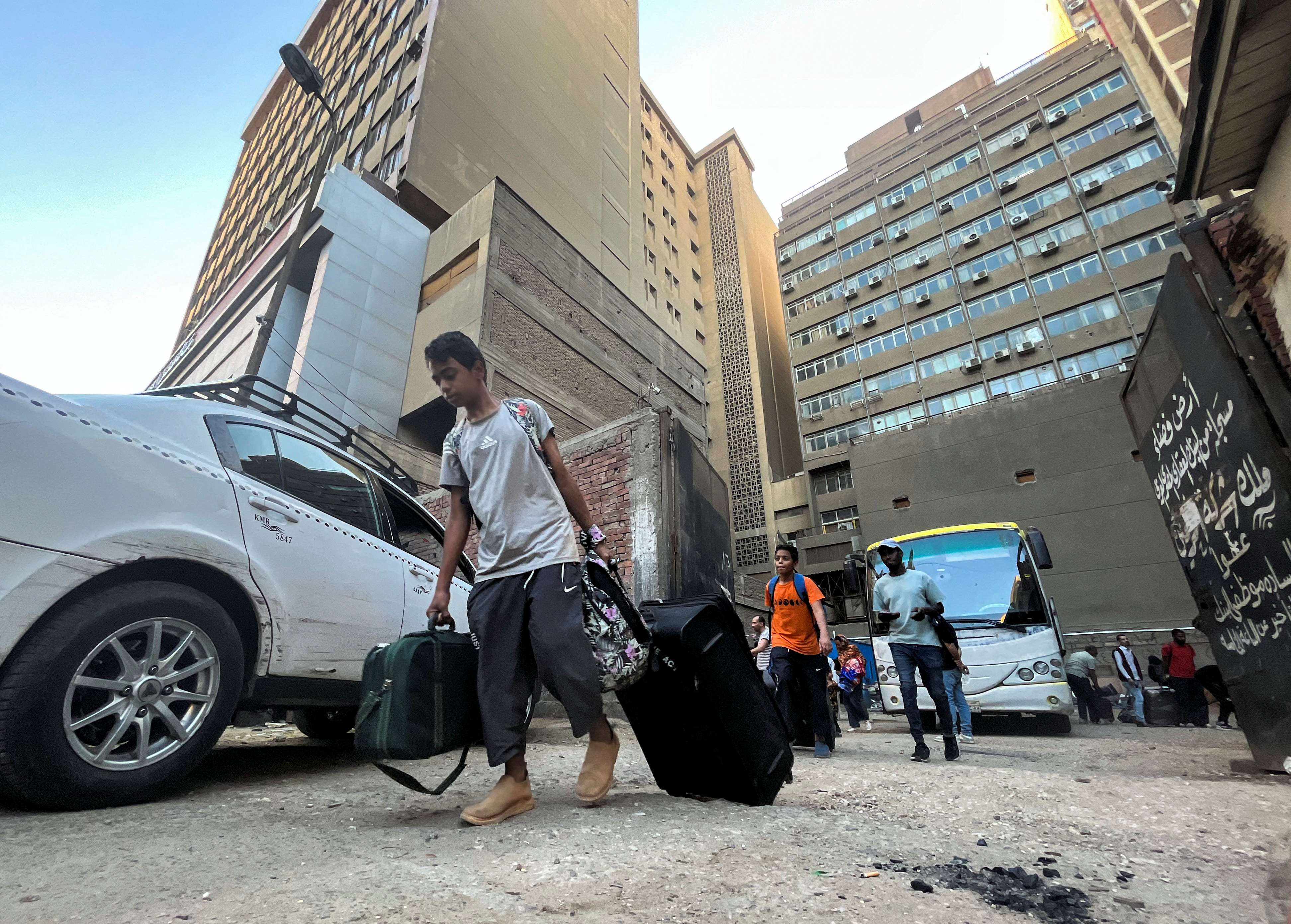 Sudanese and other nationals arrive by bus in the Egyptian capital, Cairo