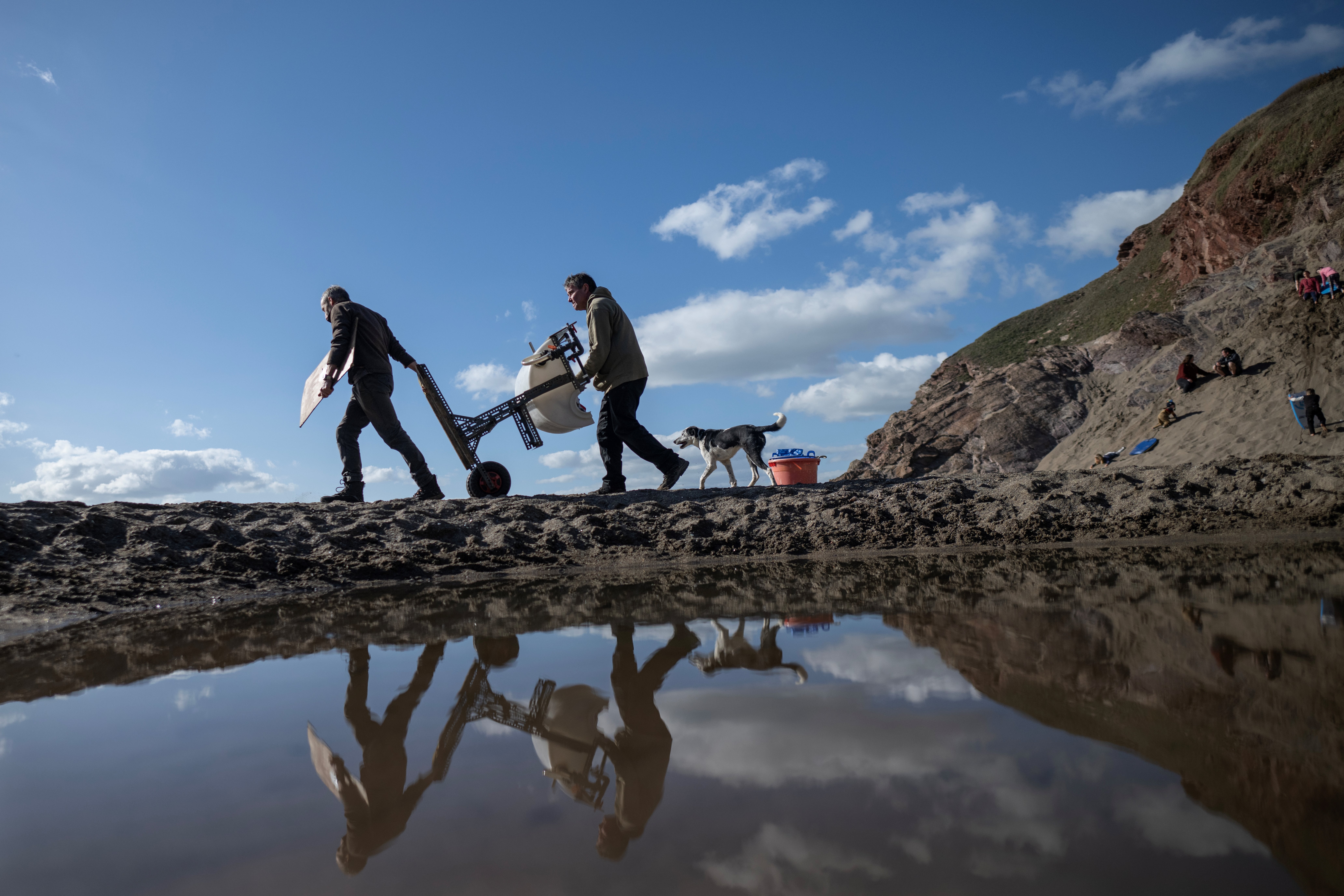 Environmental activists Jed Louis (R) and artist Rob Arnold (L) carry a machine used to filter nurdles