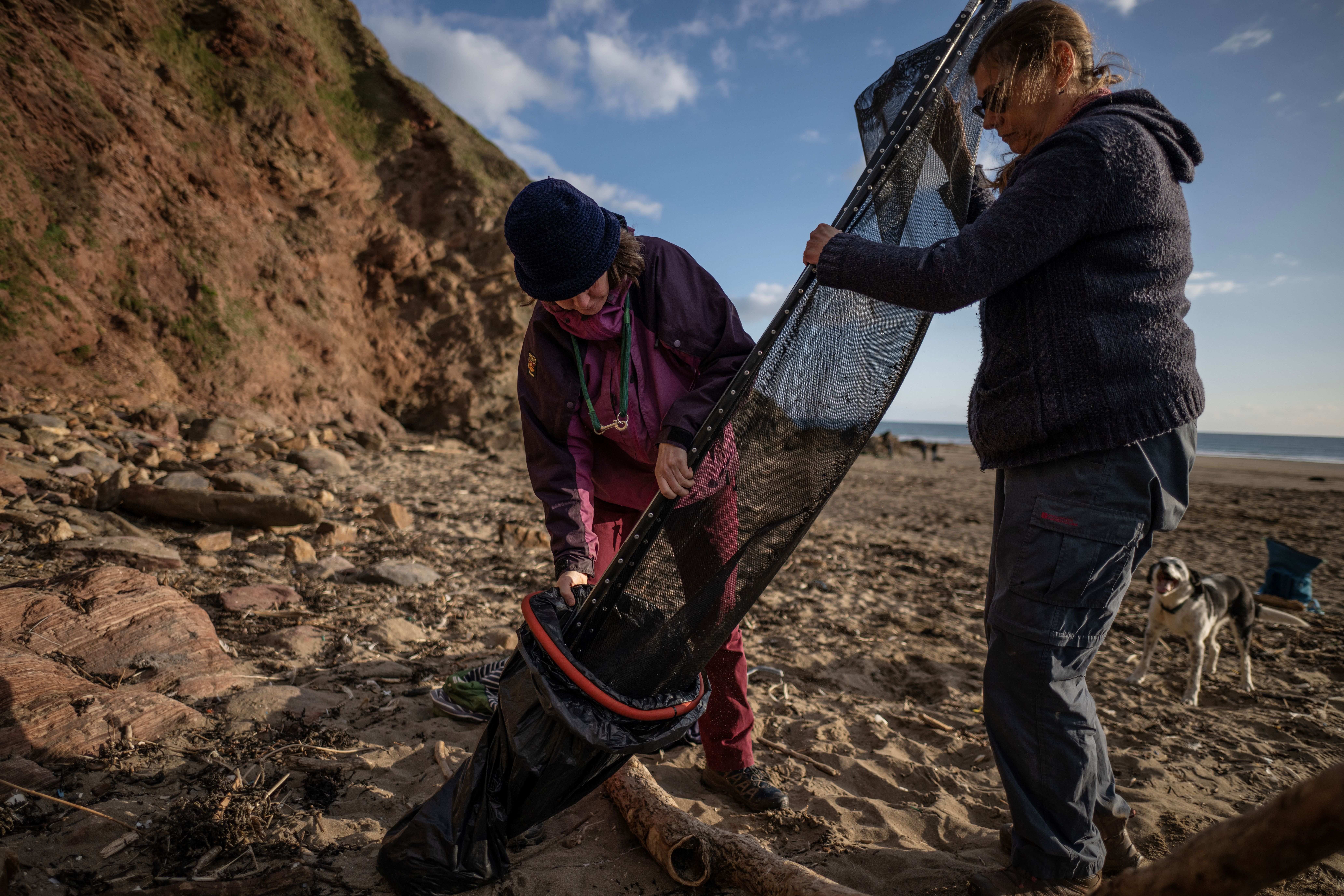 Volunteers take part in a beach clean organised to collect nurdles and other plastic waste on the Tregantle beach part of the Whitesand Bay