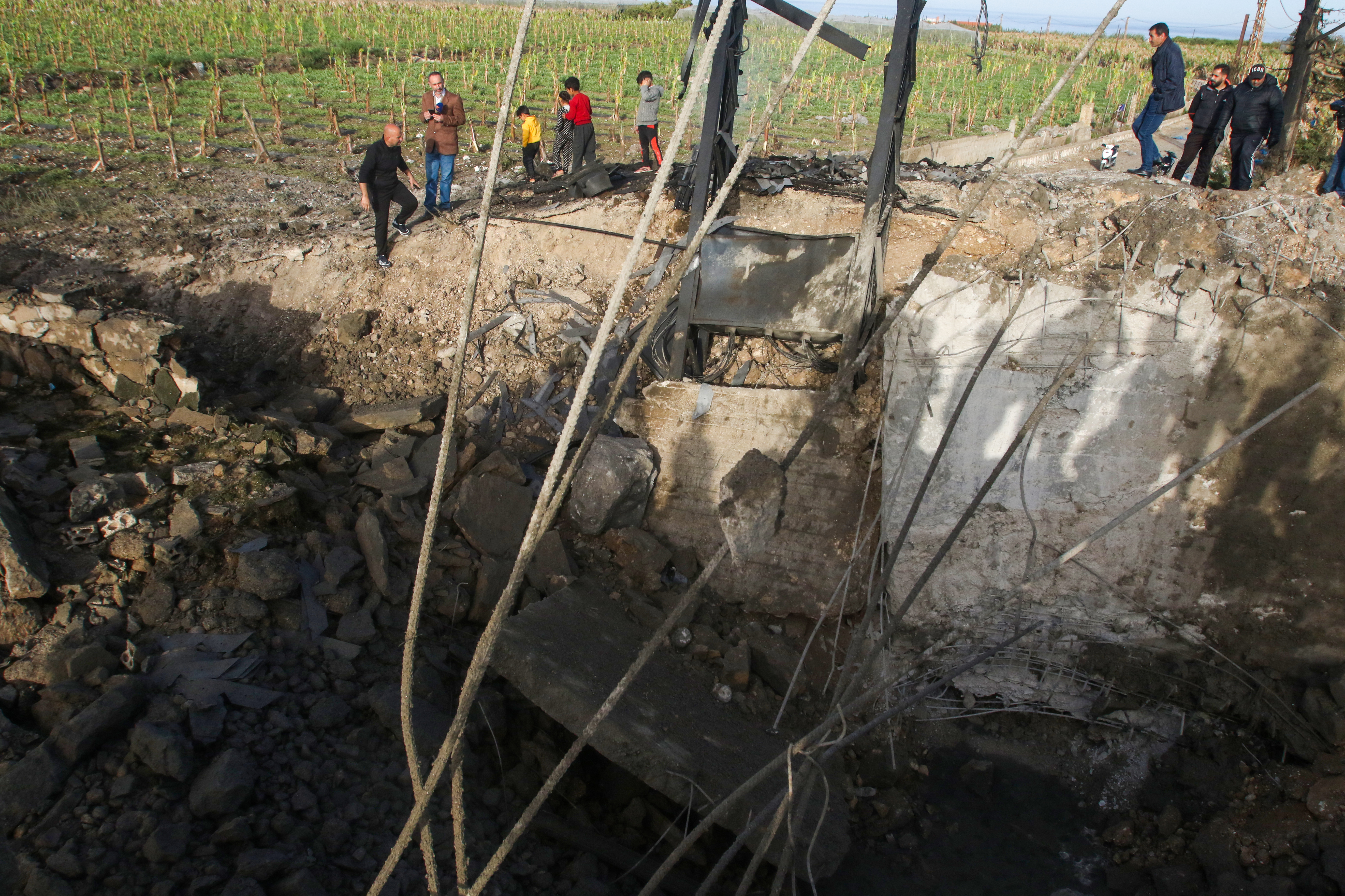 People check a damaged bridge following Israeli air strikes in Al Qulaylah, on the outskirts of Tyre, on April 7, 2023