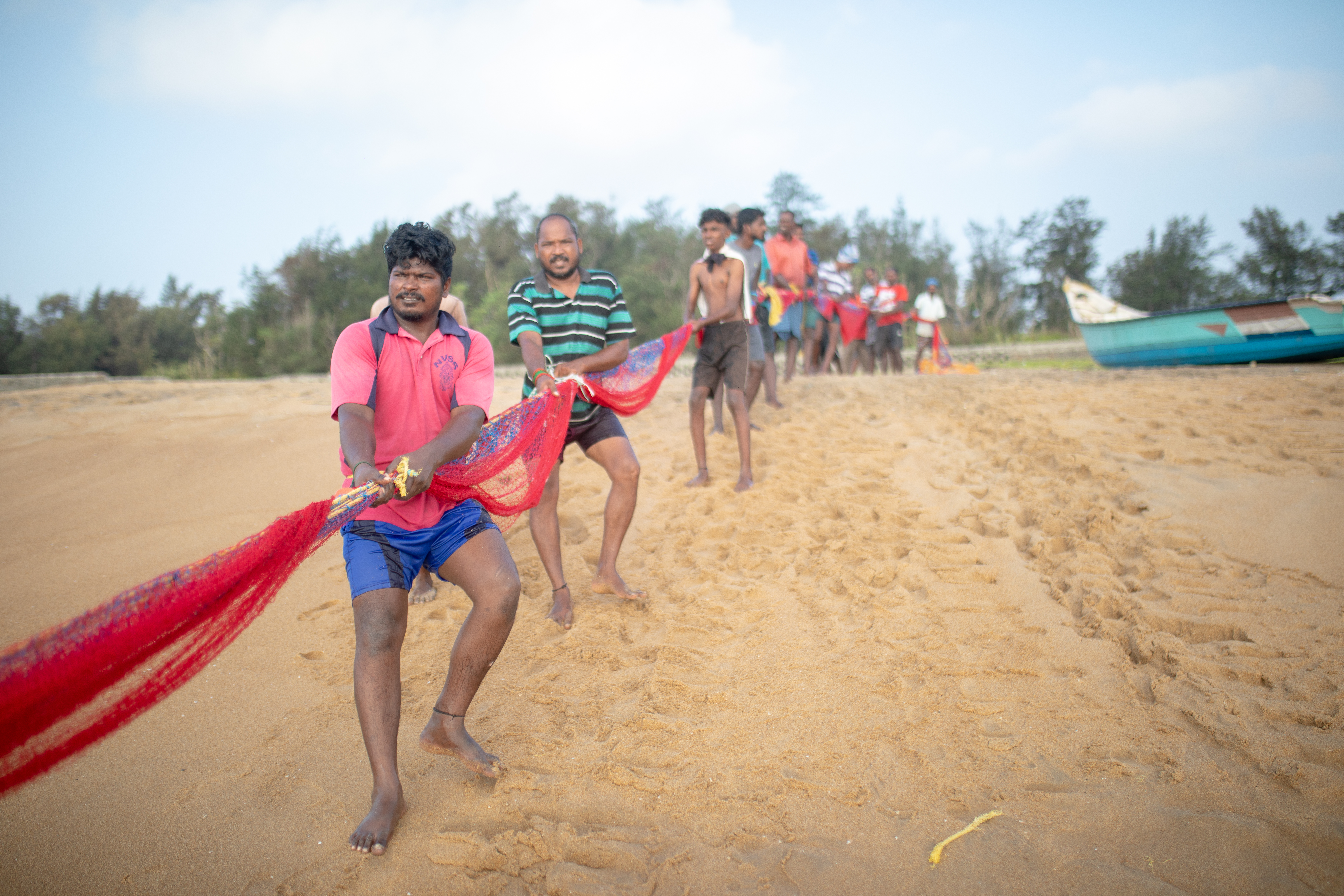 A photo of people pulling a long read rope.