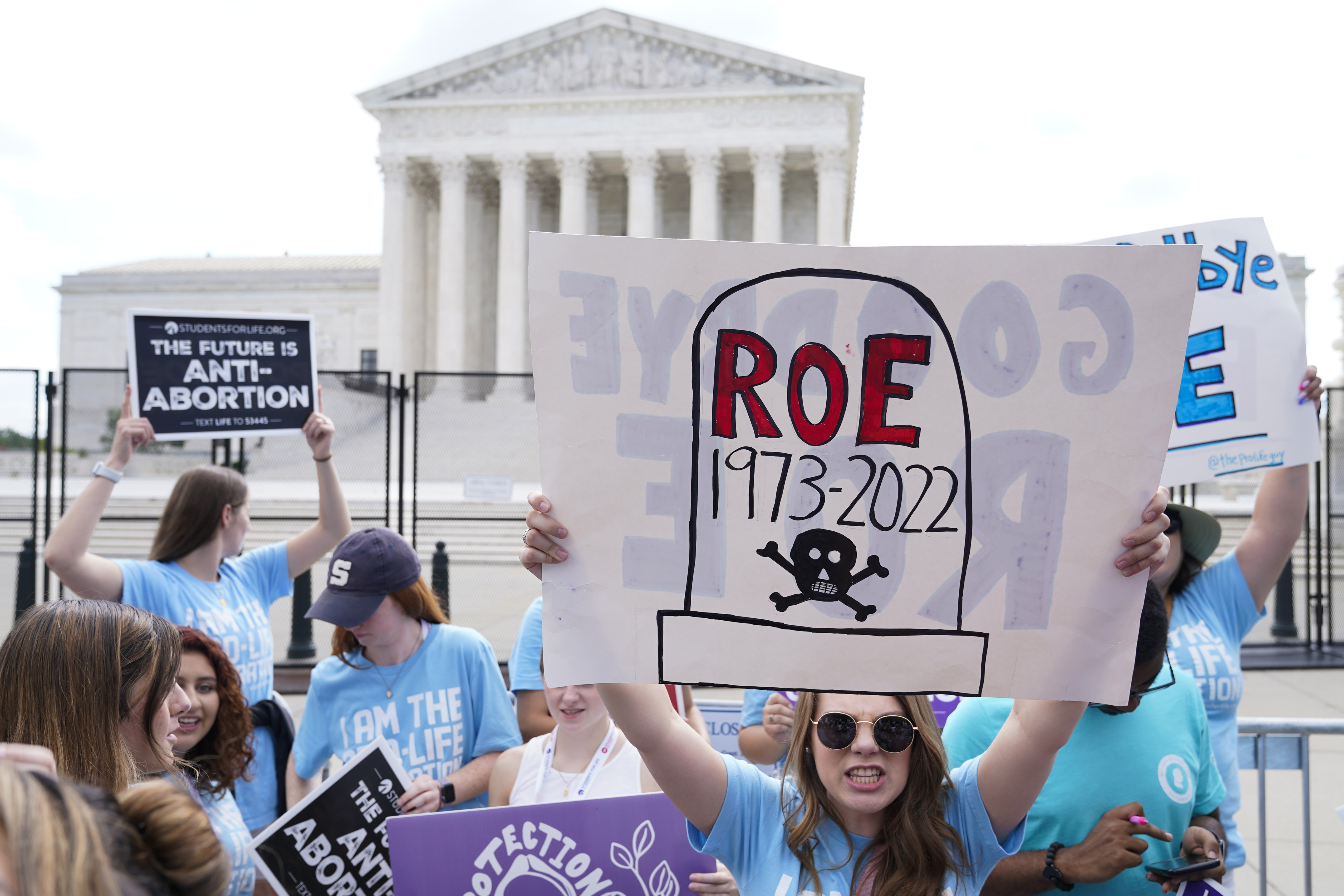 Anti-abortion rights groups hold up signs against abortion in front of the Supreme Court