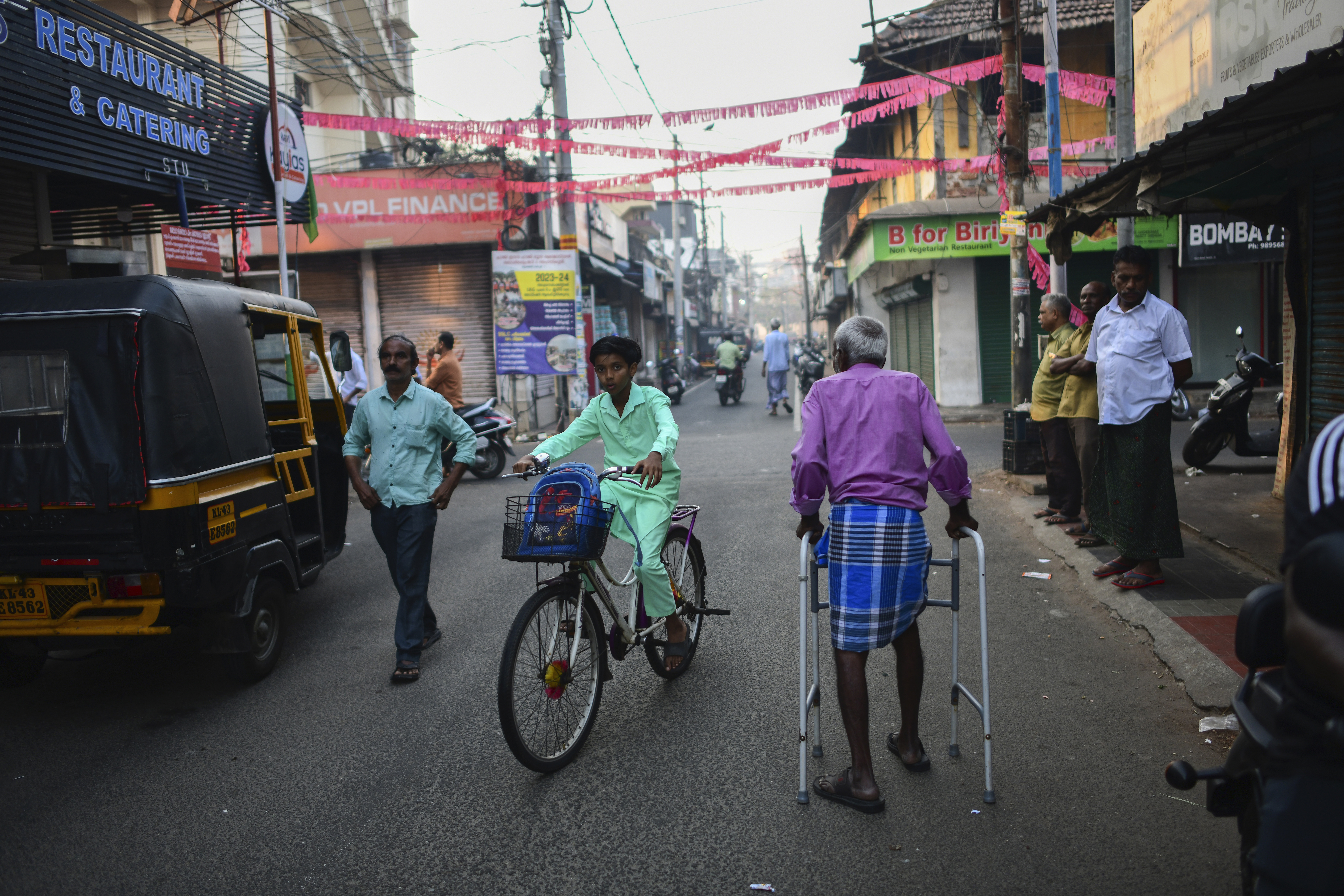 An elderly man walks through a street in Mattancherry