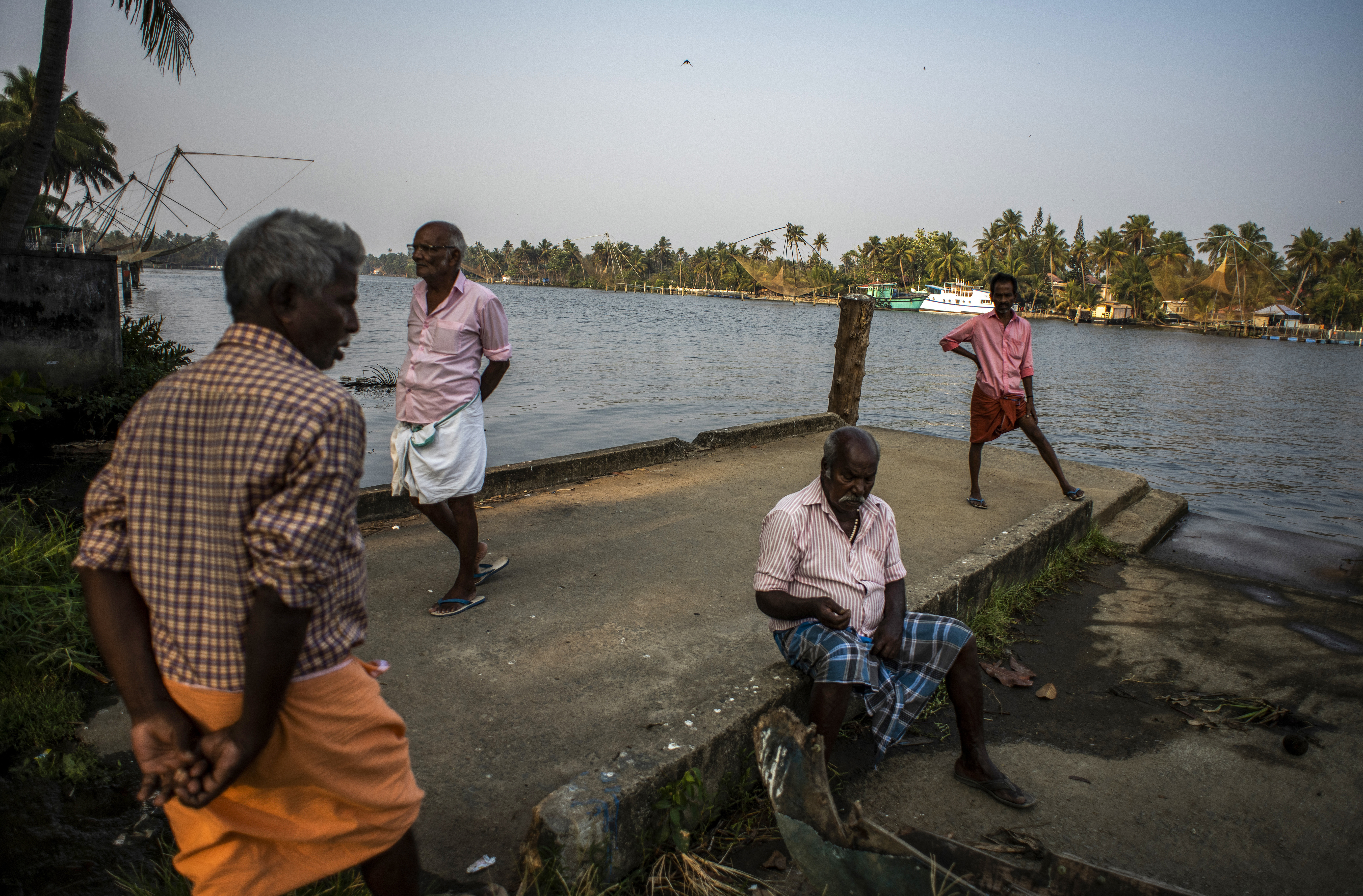 Elderly men idle away an evening by the backwaters in Kochi