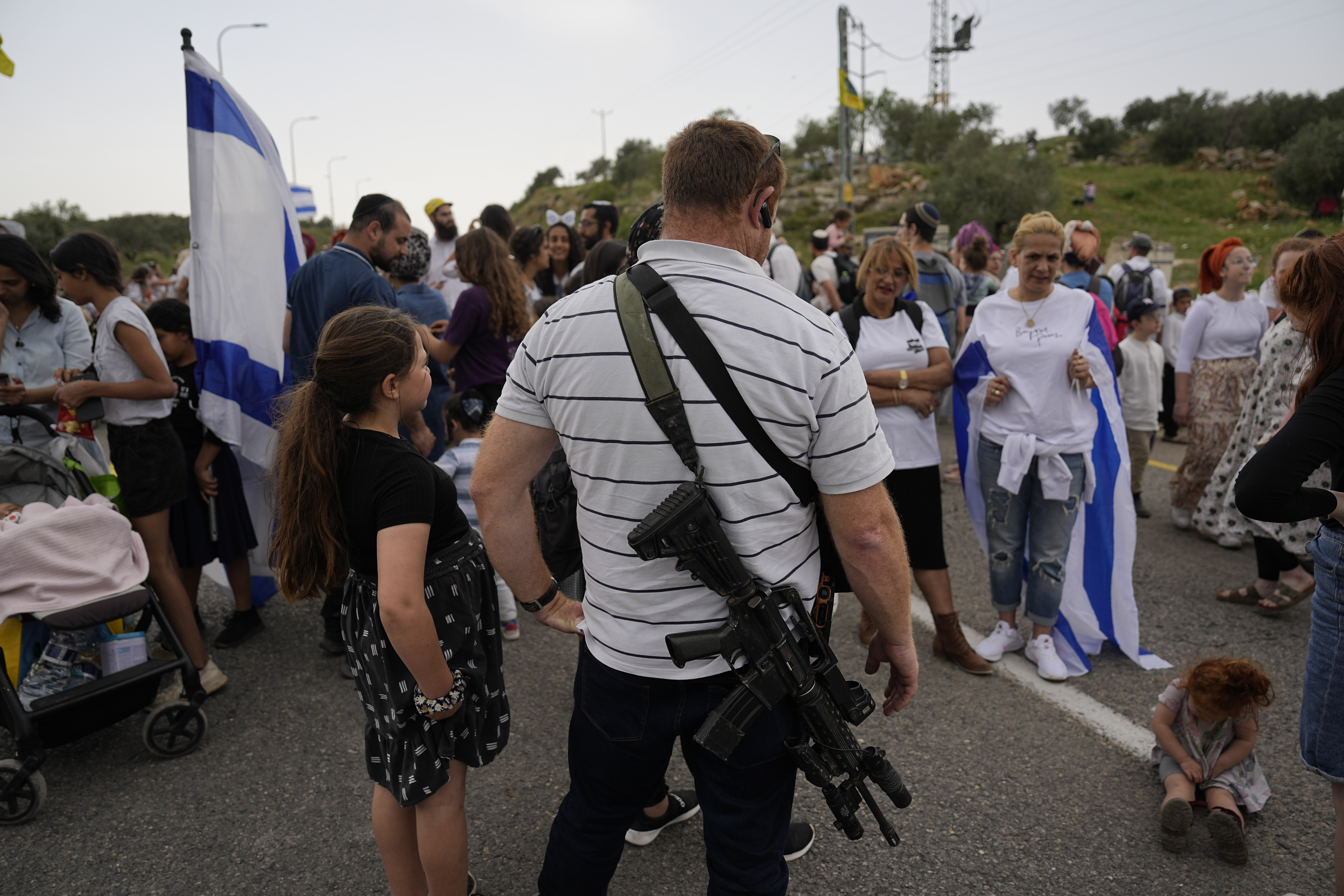 Israeli settlers stand near the outpost of Eviatar