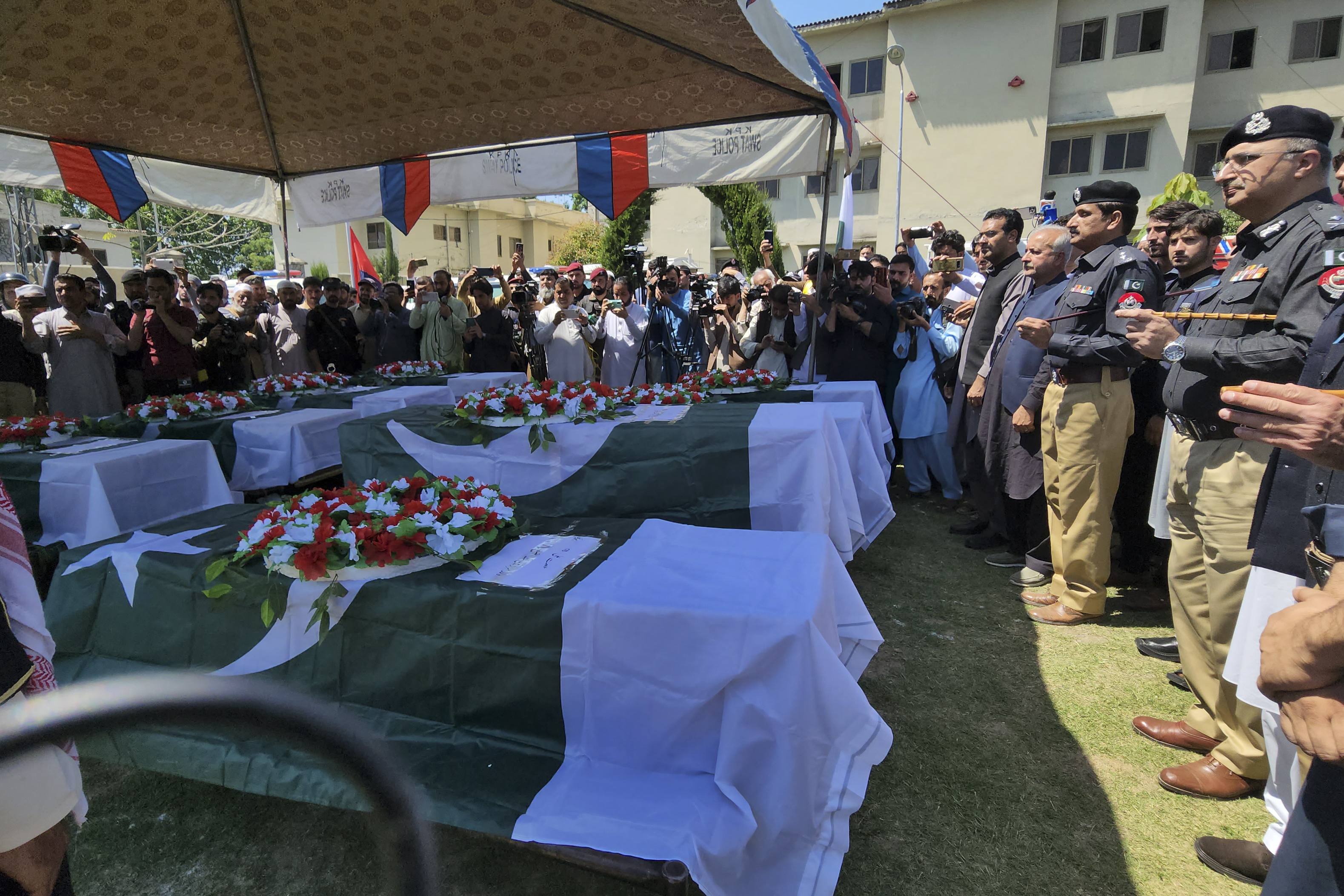 Officials and others attend the funeral prayer of police officers, who were killed in the Monday's explosions in Kabal, a town of Pakistan's the Swat distric