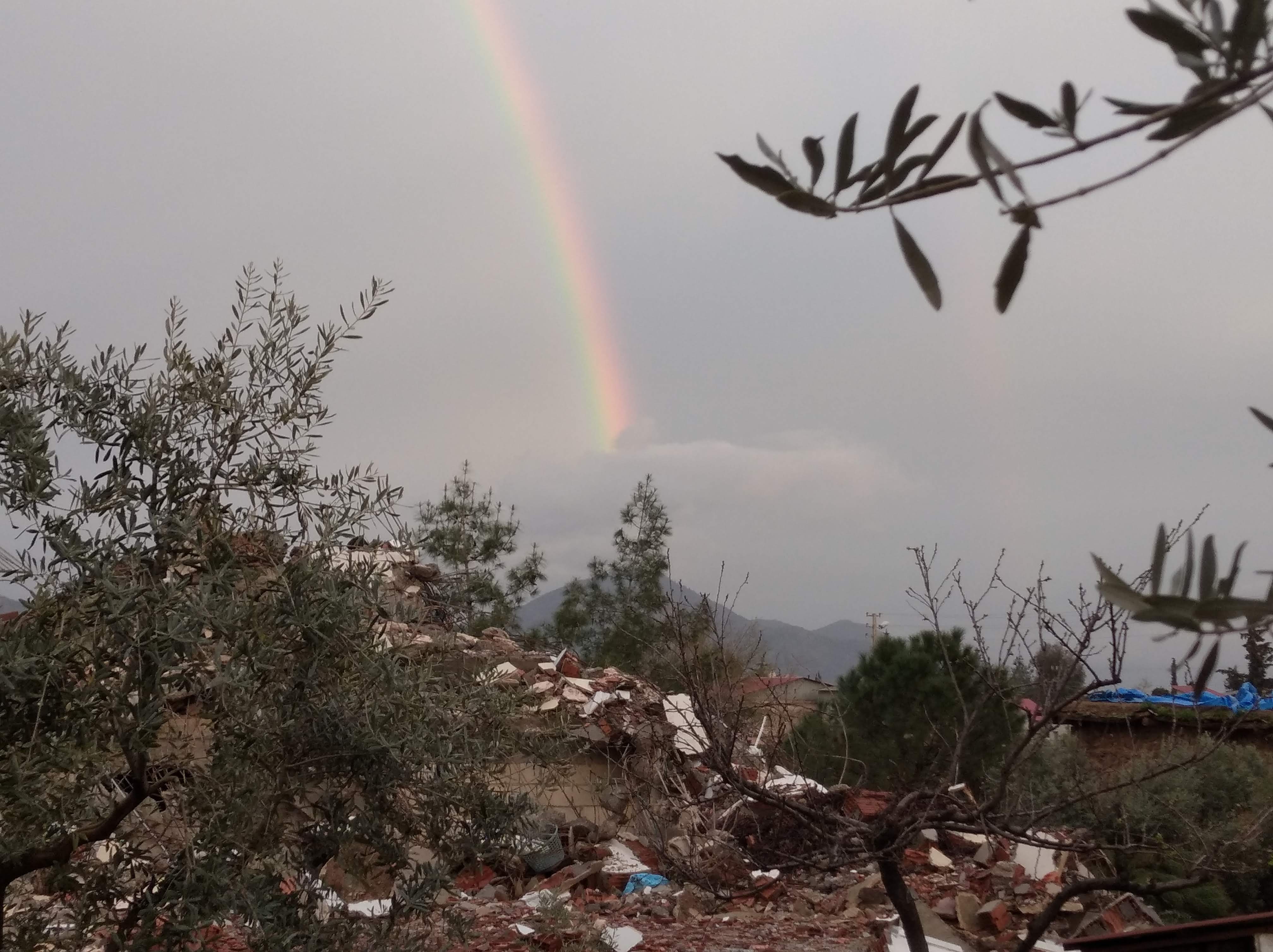 A rainbow appears above the rubble surrounding Artar's house.