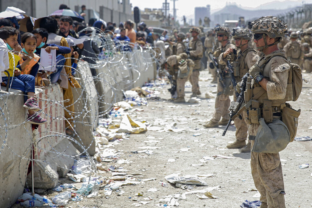 A line of soldiers survey a crowd of Afghans during the evacuations at the Kabul airport in Afghanistan.