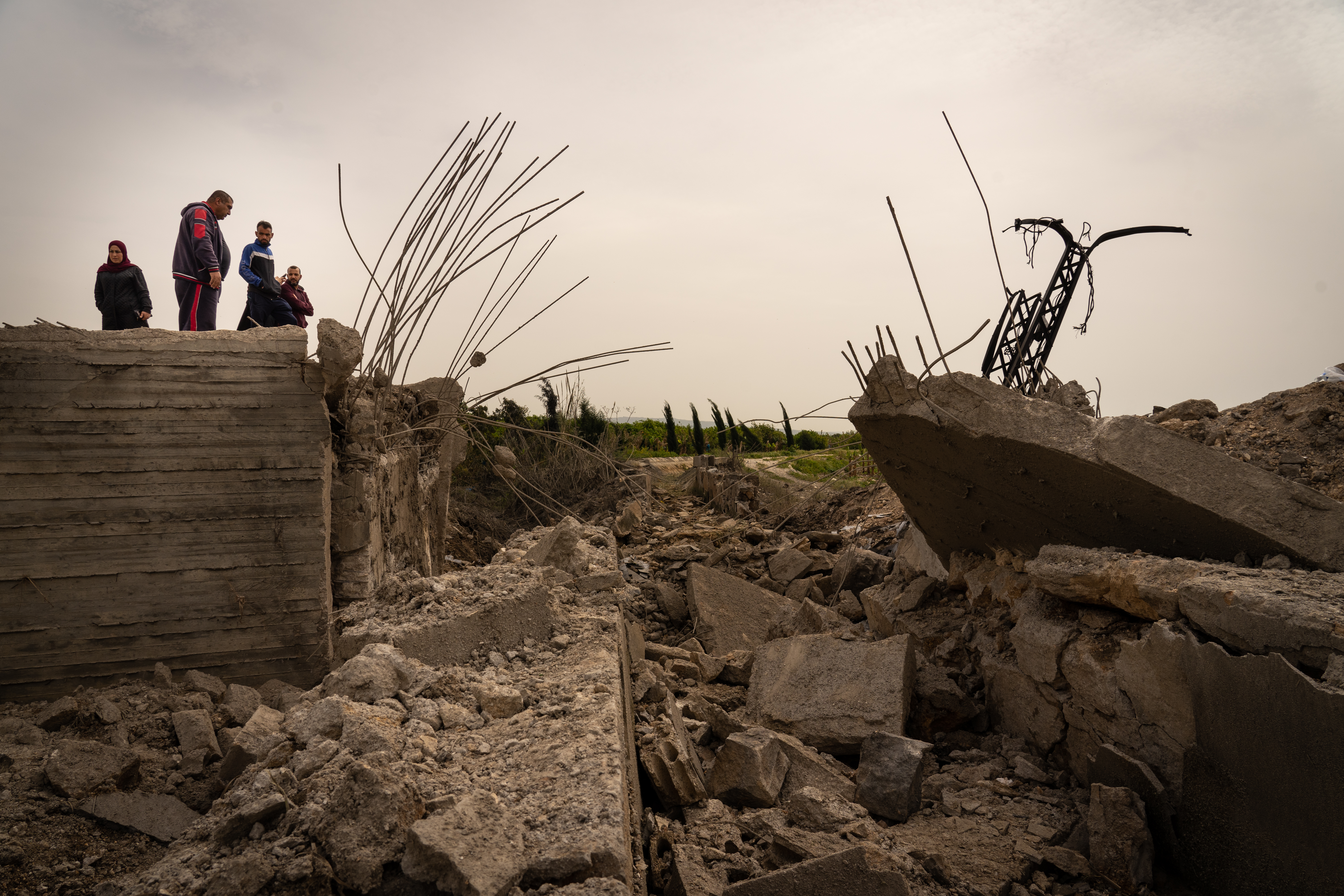Onlookers inspect the damage made to a rural bridge and irrigation project