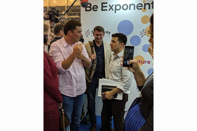 A photo of Igor on the right speaking to Zelensky on the right.