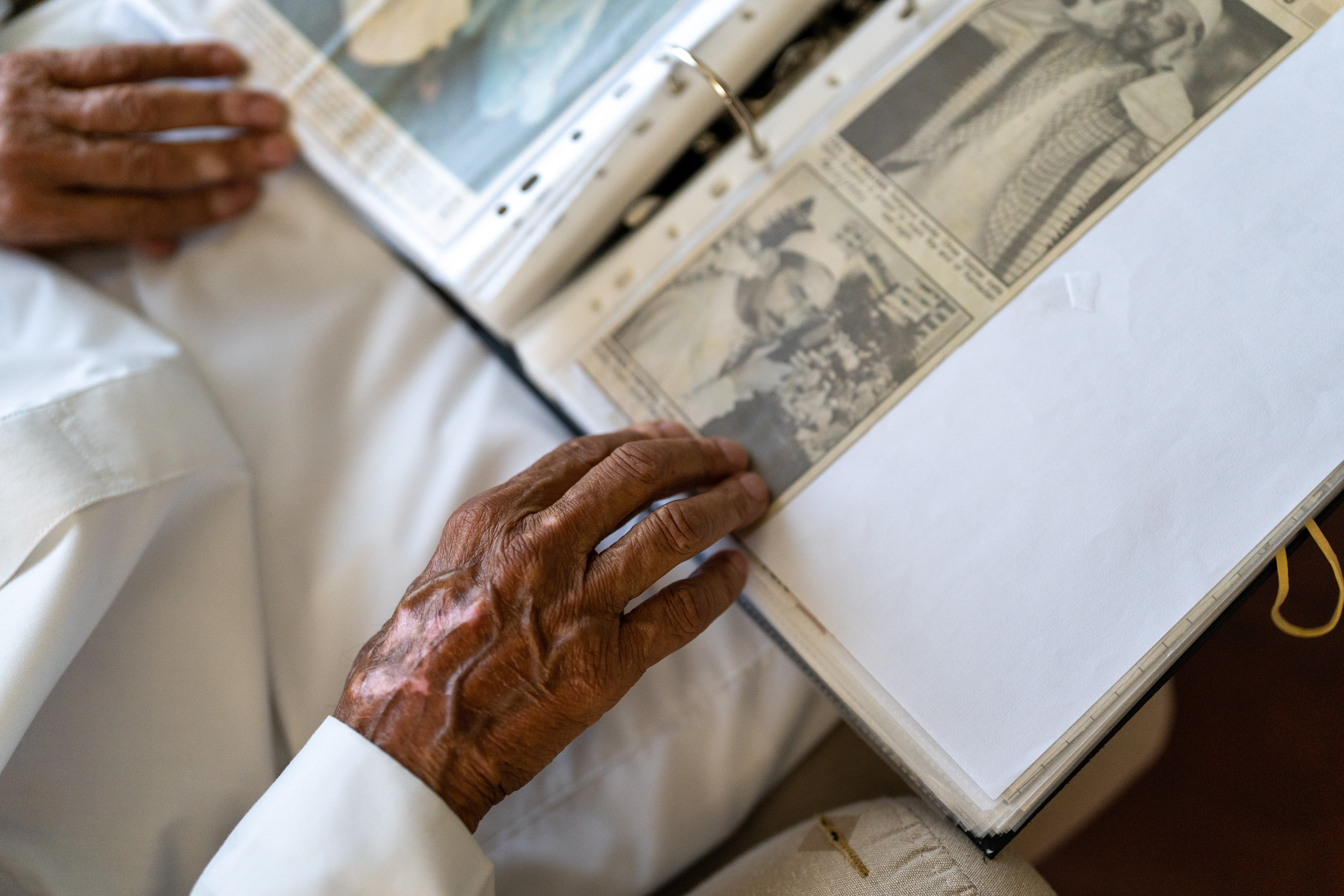 A photo of Imam Yusuf Pandy looking through an album.