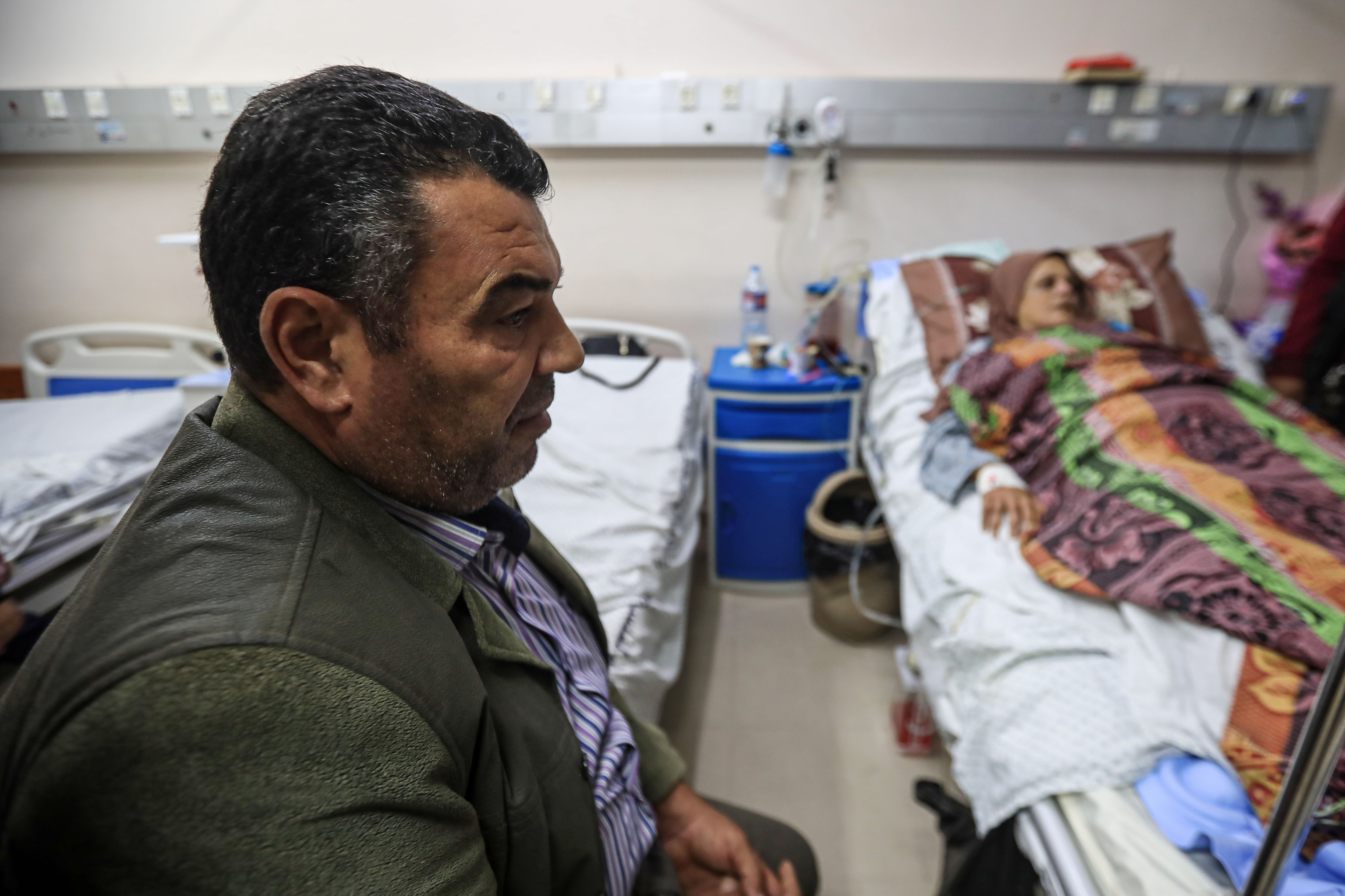 A man sits next to his wife's bed