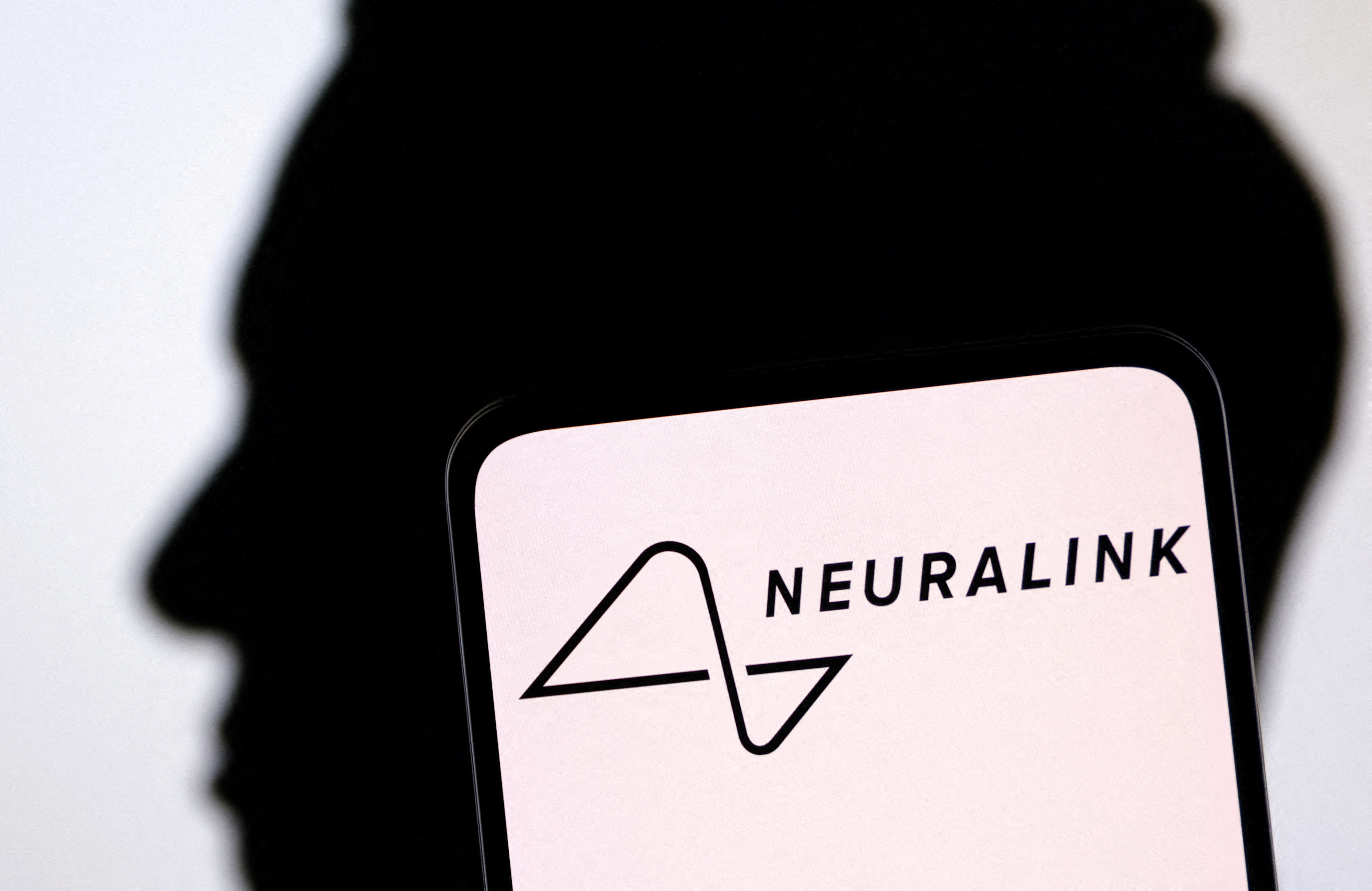Neuralink logo and Elon Musk silhouette are seen in this illustration taken, December 19, 2022. REUTERS/Dado Ruvic/Illustration