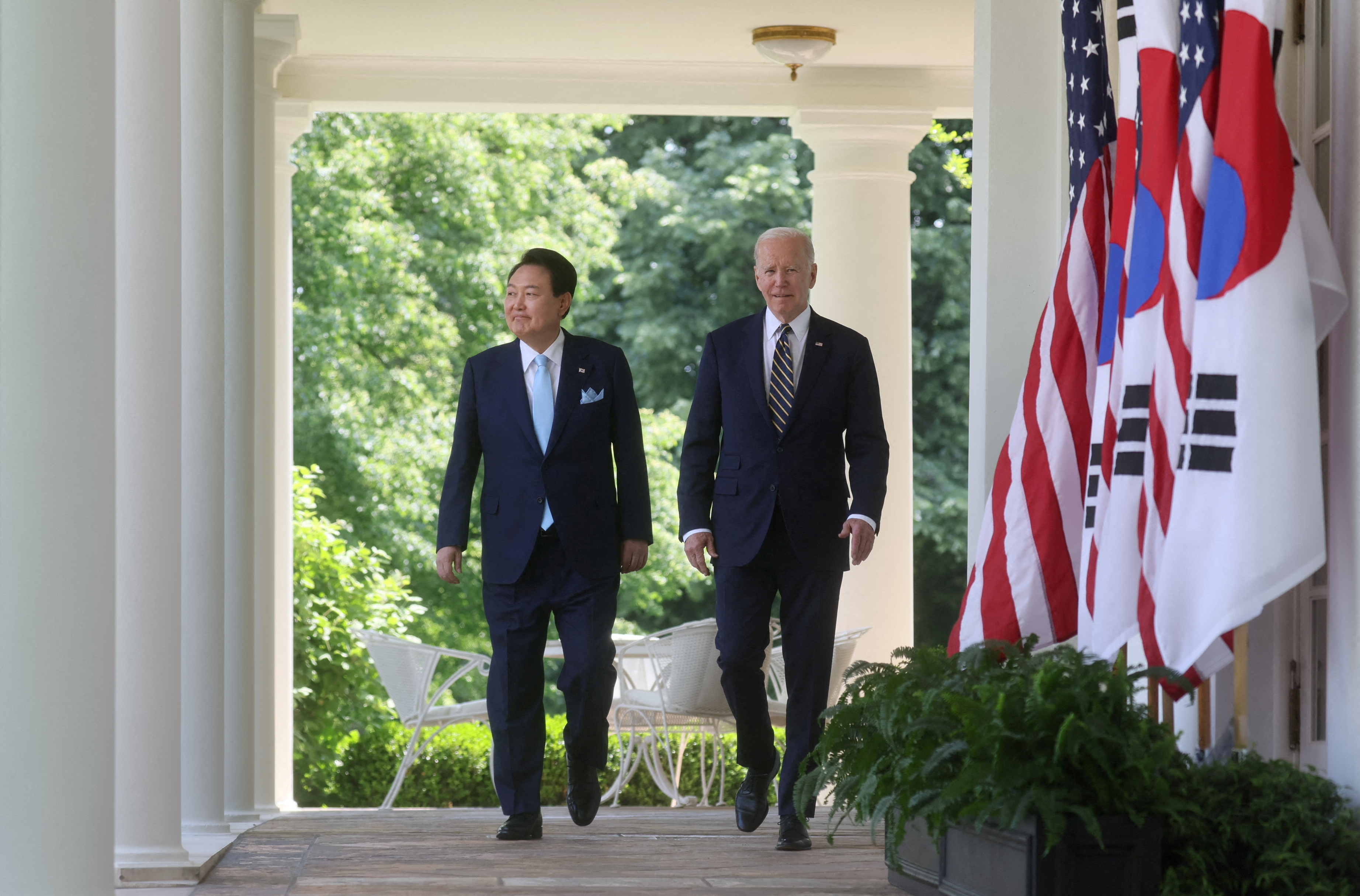 South Korea President Yoon Suk-yeol and US President Joe Biden walking through a colonnade at the White House.