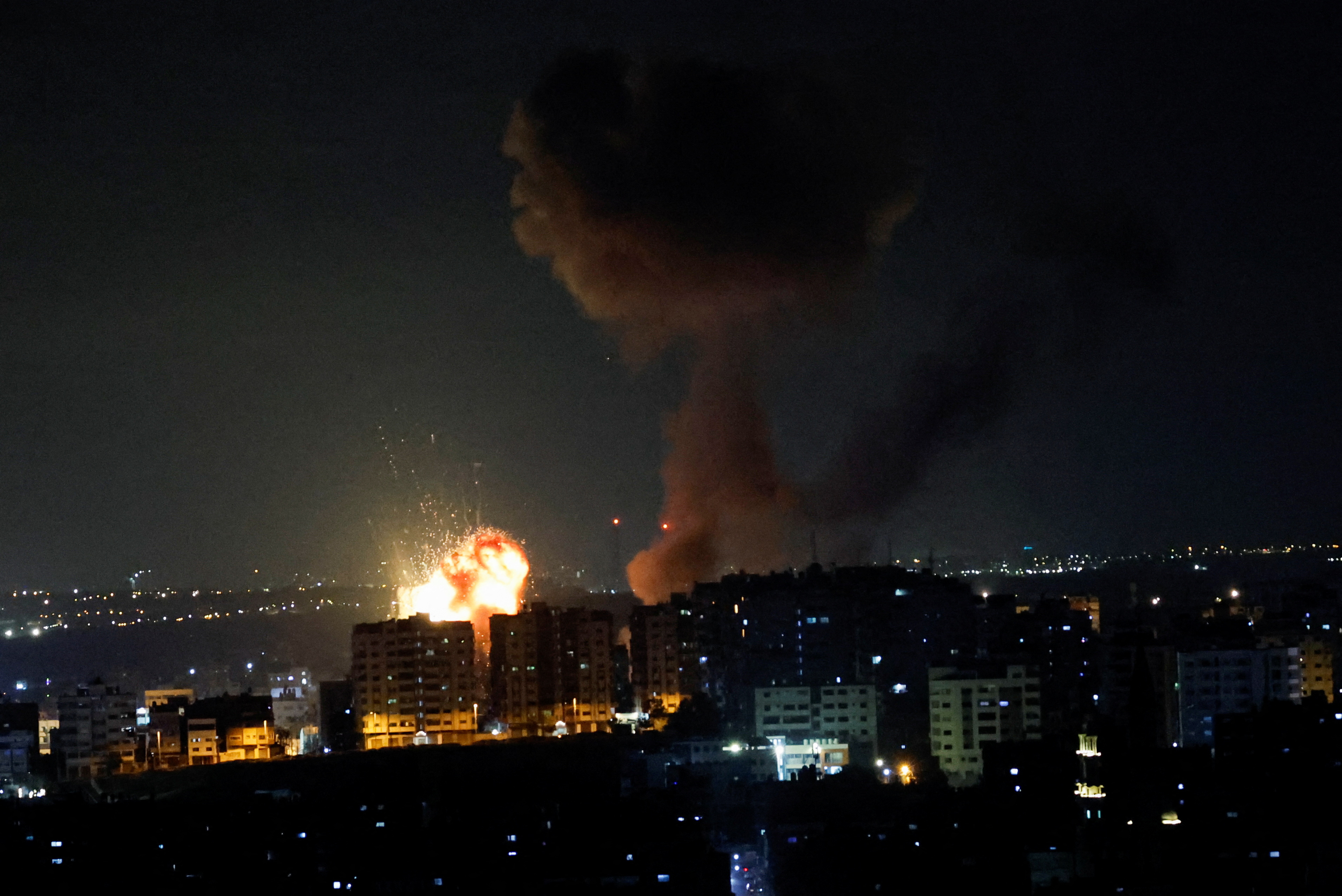 An explosion and smoke rising are seen as Israel strikes Gaza.