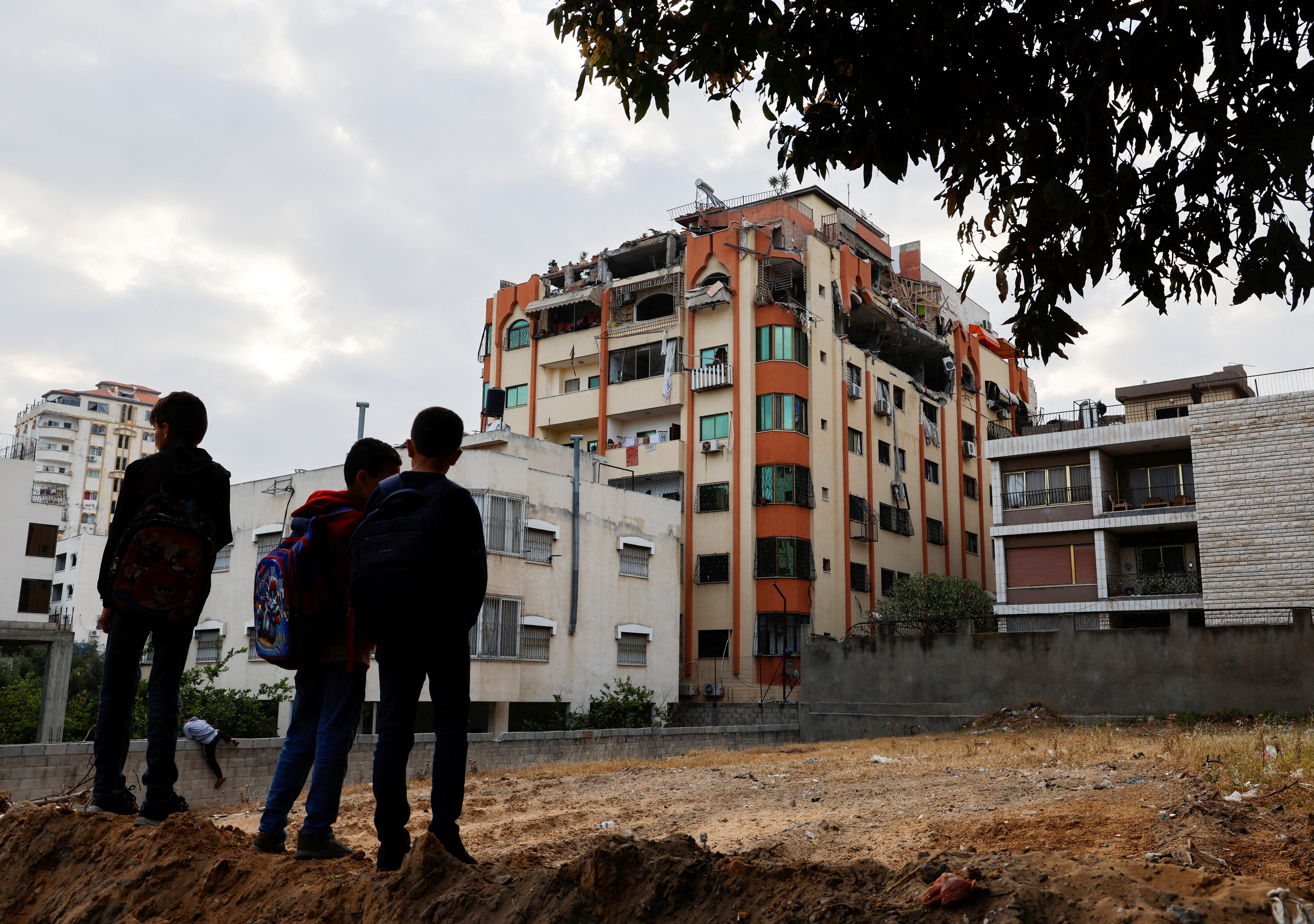 Children stand near a damaged building in the aftermath of Israeli military strikes on Islamic Jihad targets, in Gaza.