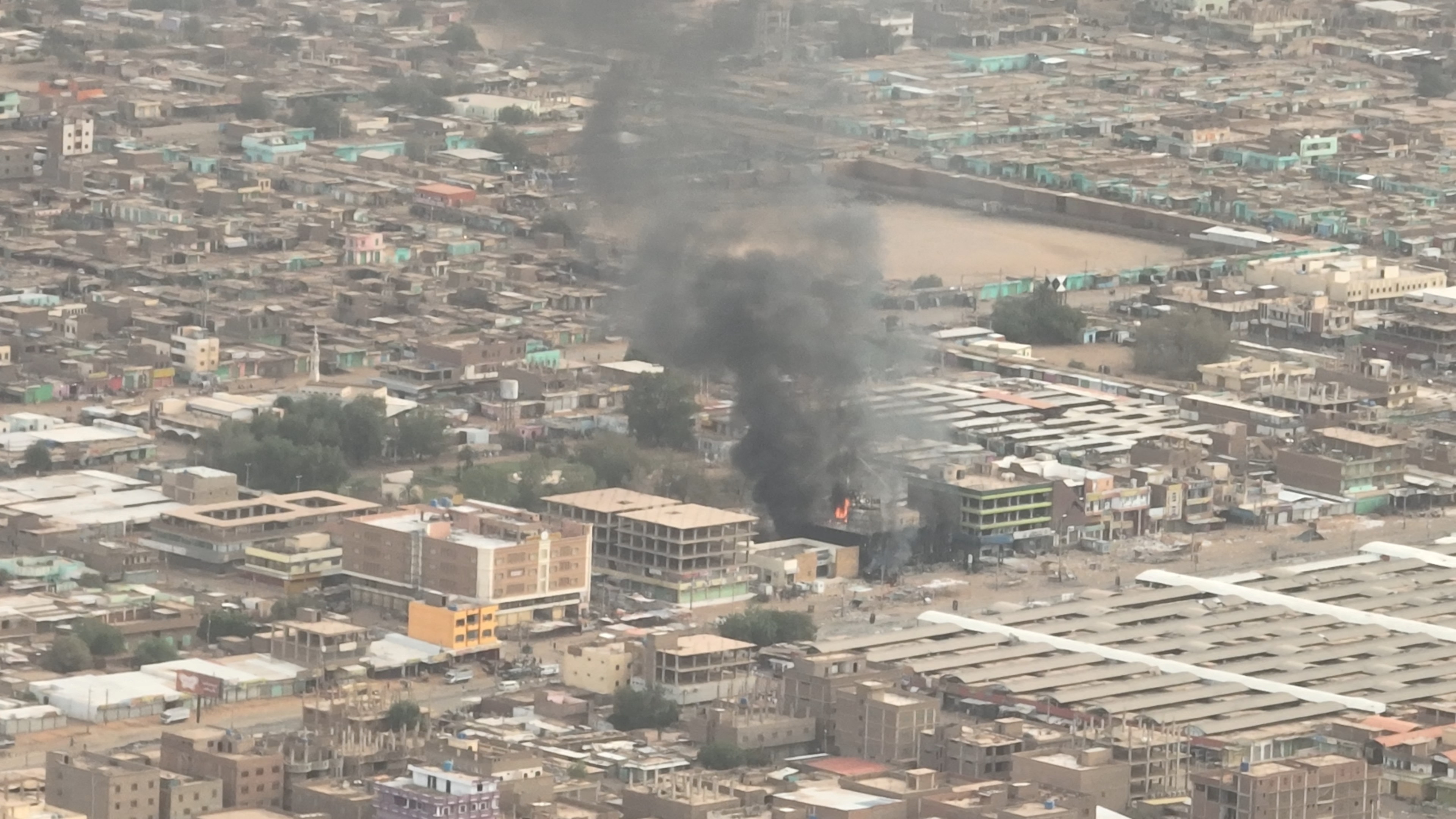An aerial shot shows smoke rising from a bank in Sudan