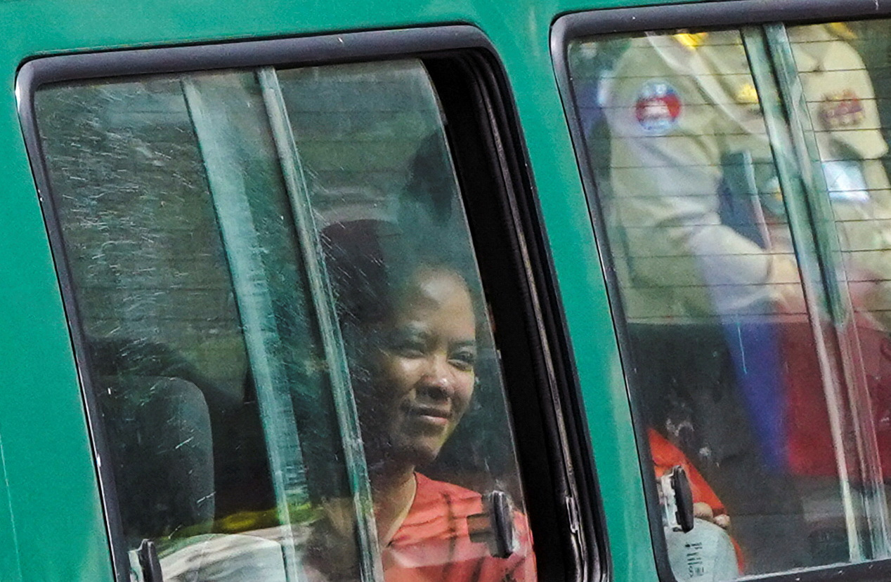 Chhim Sithar leaving in Phnom Penh court in a green prison minibus.