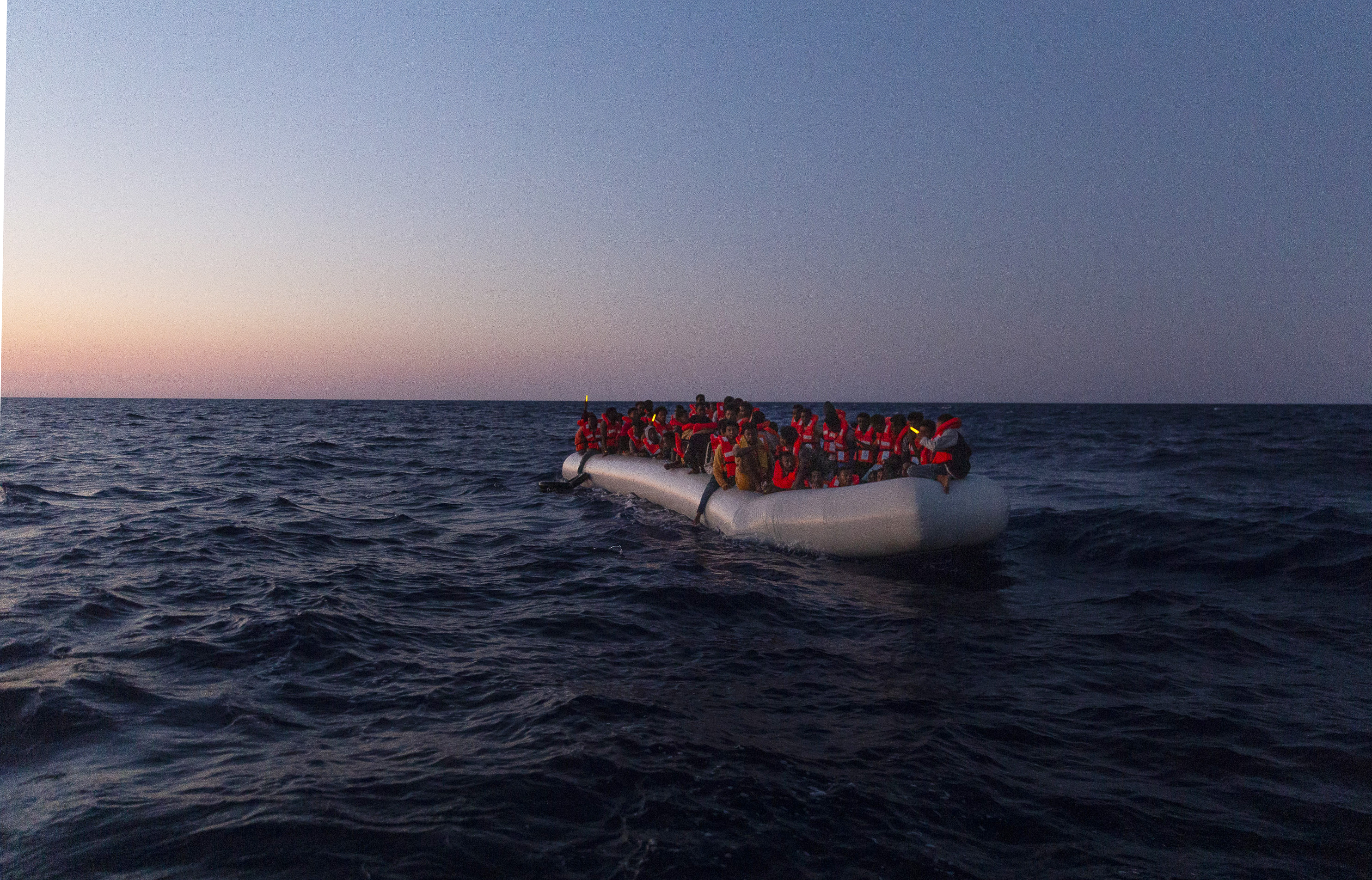 This handout picture taken and released on July 23, 2022 by the NGO Sea-Watch shows a Sea-Watch 3 crew member on a lifeboat approaching an inflatable boat in distress with 120 people on board in the central Mediterranean. (Photo by Nora Börding / SEA-WATCH / AFP) / RESTRICTED TO EDITORIAL USE - MANDATORY CREDIT "AFP PHOTO /SEA-WATCH / NORA BORDING " - NO MARKETING - NO ADVERTISING CAMPAIGNS - DISTRIBUTED AS A SERVICE TO CLIENTS - RESTRICTED TO EDITORIAL USE - MANDATORY CREDIT "AFP PHOTO /Sea-Watch / NORA BORDING " - NO MARKETING - NO ADVERTISING CAMPAIGNS - DISTRIBUTED AS A SERVICE TO CLIENTS /