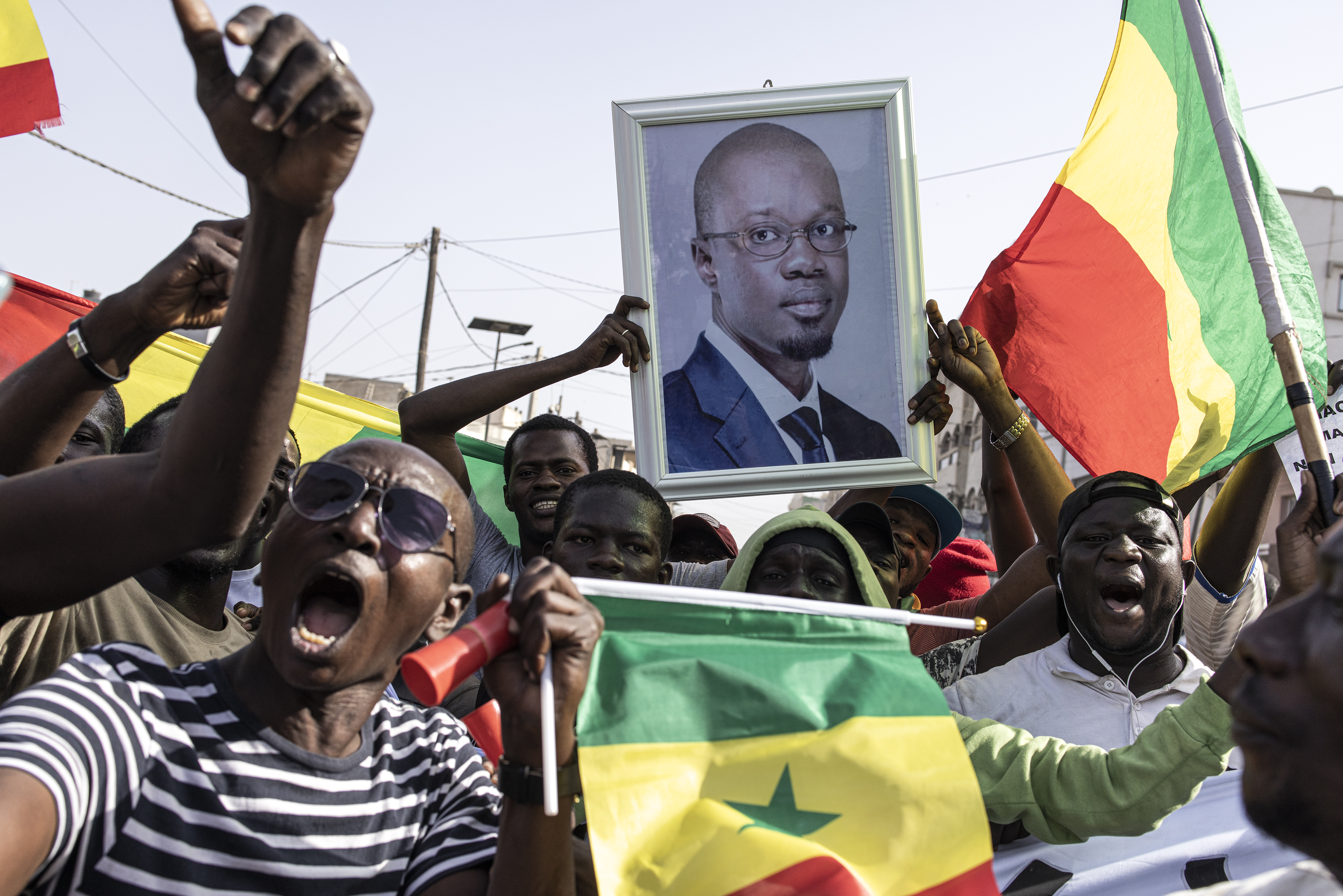 Opposition supporters sing and dance during a meeting two days before the trial of one of the leaders, Ousmane Sonko, in Dakar on March 14, 2023. (Photo by JOHN WESSELS / AFP)