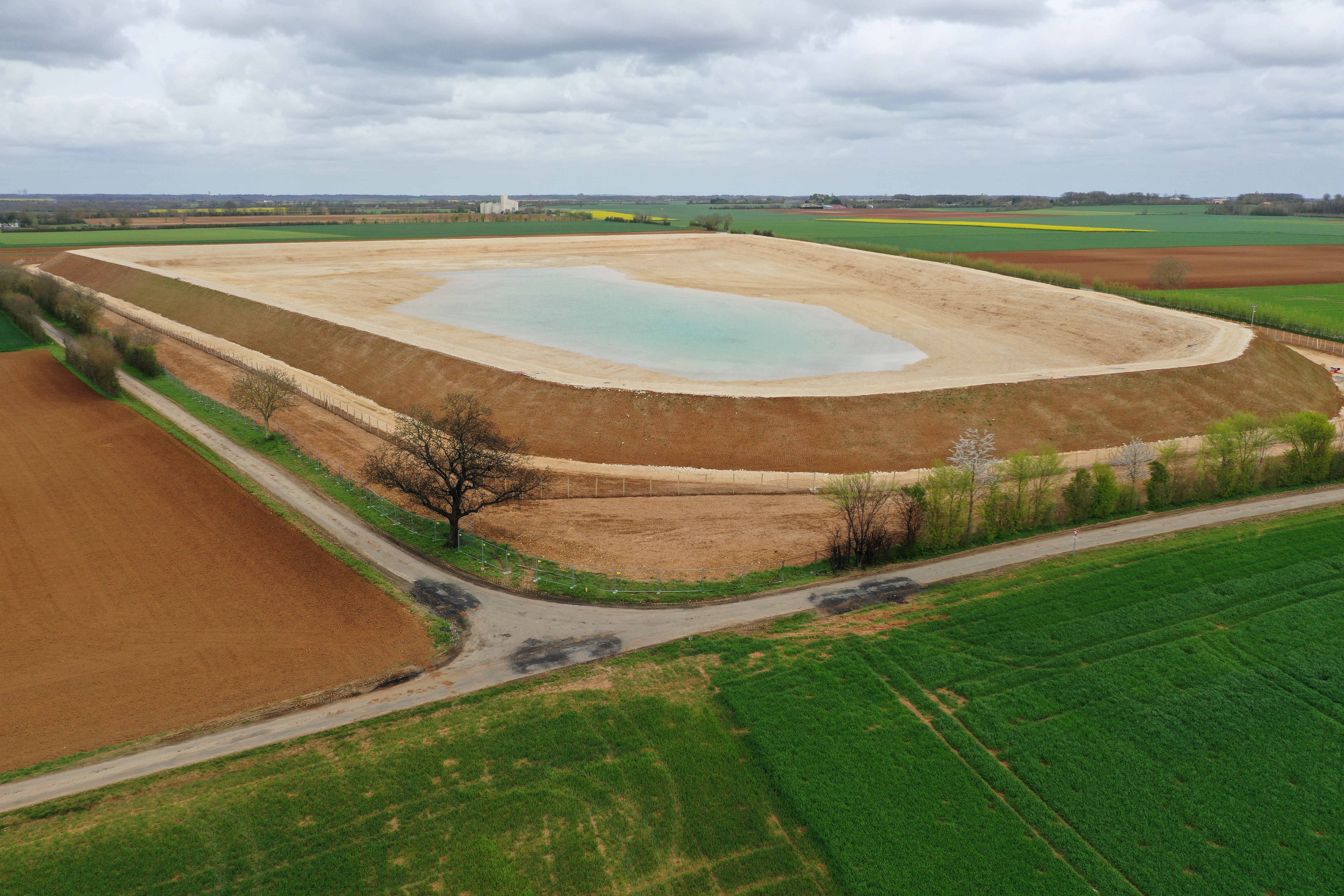 This aerial view taken on April 11, 2023 shows a water reserve for agricultural irrigation under construction, in Sainte-Soline, central-western France. - The project comprises 16 reservoirs with a total capacity of six million cubic metres, planned by a cooperative of 450 farmers with state support. It aims to store water drawn from the water table in winter to irrigate crops in summer when rainfall is scarce, according to a "substitution" principle. Its supporters see it as a condition for the survival of farms in the face of the threat of recurrent droughts. (Photo by Damien MEYER / AFP)