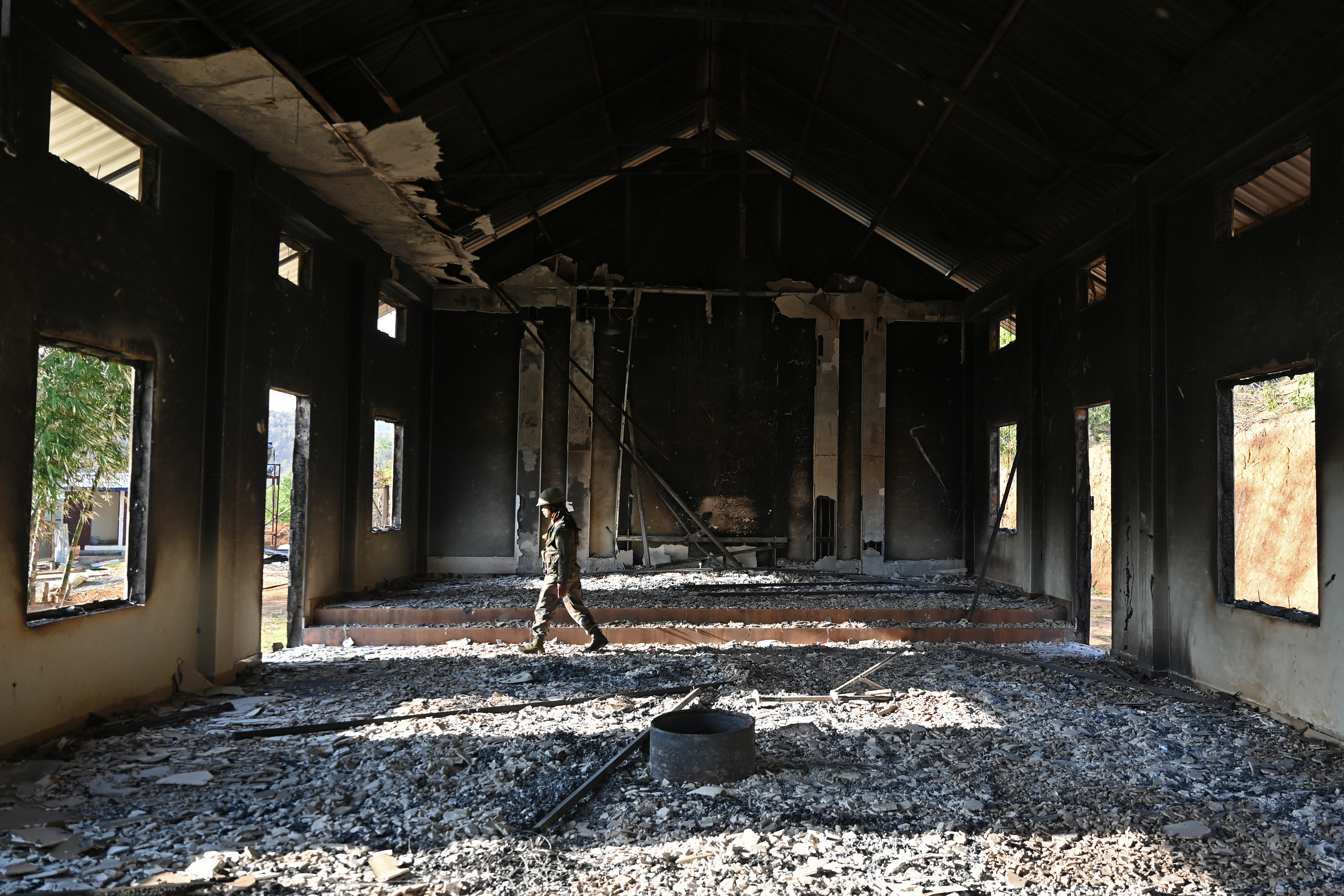 An Indian army soldier inspects the debris of a ransacked church that was set on fire by a mob in the ethnic violence hit area of Heiroklian village in Senapati district, in India's Manipur